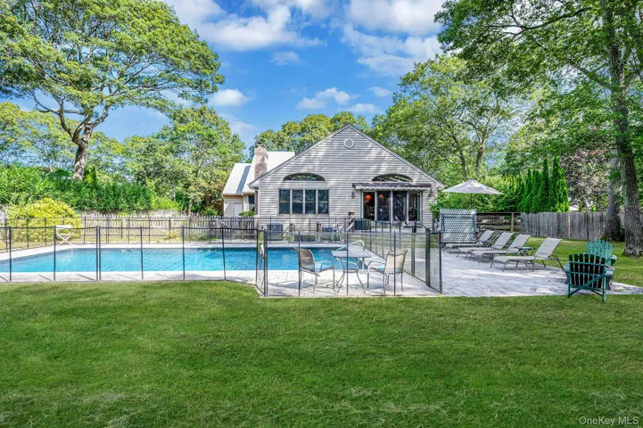 View of swimming pool featuring a patio and view of wooded area