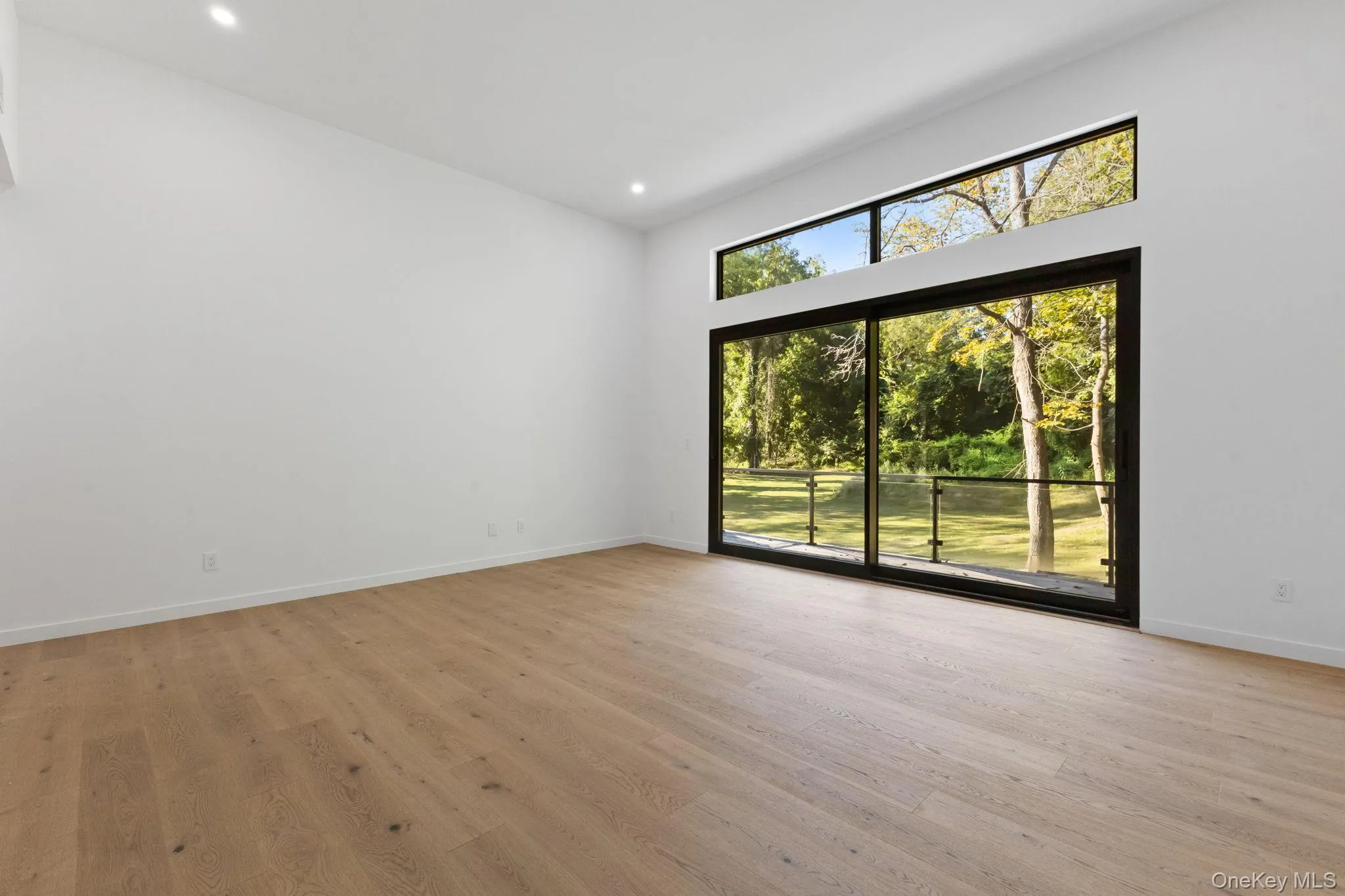 Unfurnished living room featuring light wood-type flooring and recessed lighting Unfurnished living room featuring light wood-type flooring and recessed lighting