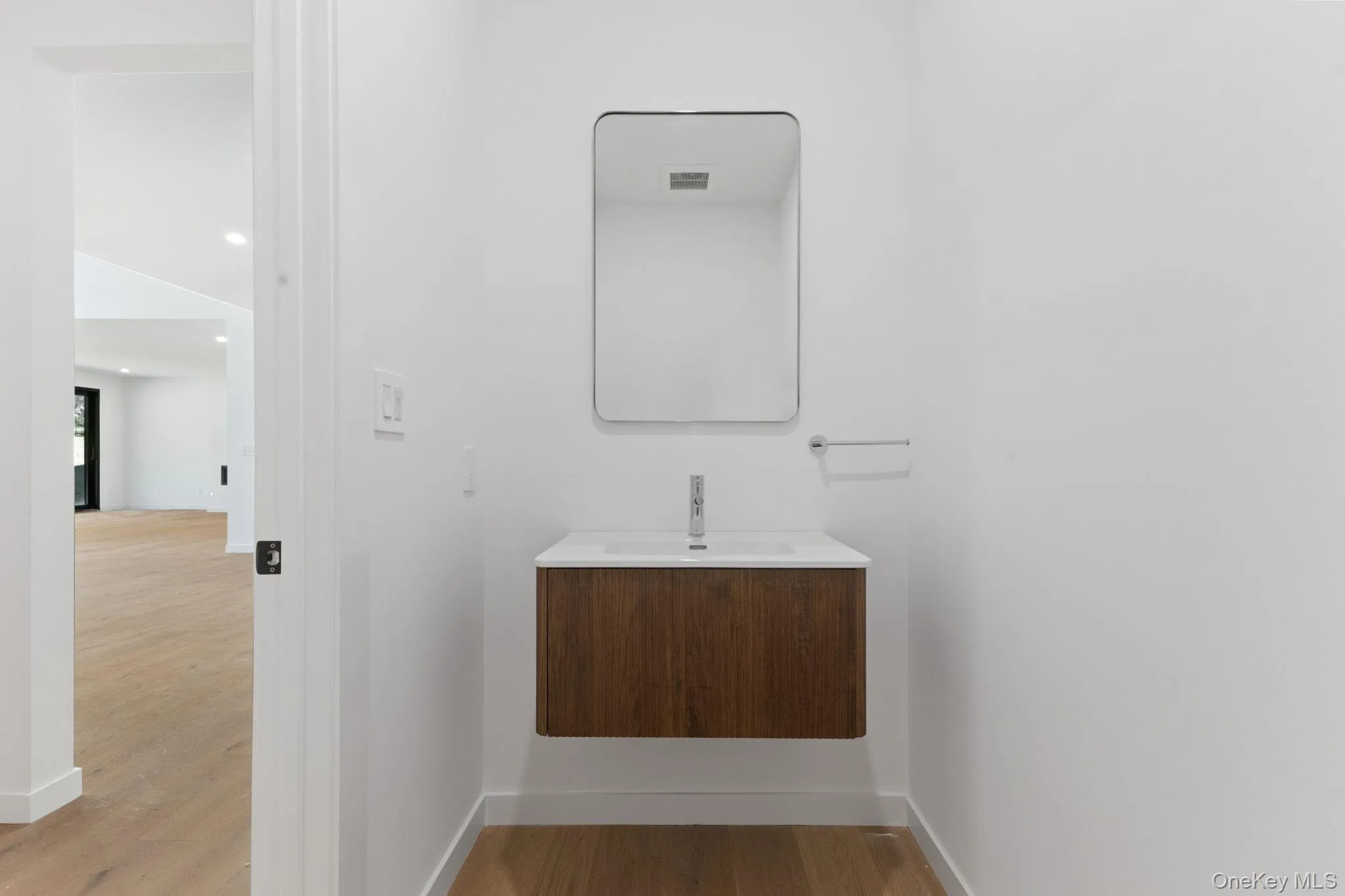 Half bath with vanity, wood finished floors, and recessed lighting Half bath with vanity, wood finished floors, and recessed lighting