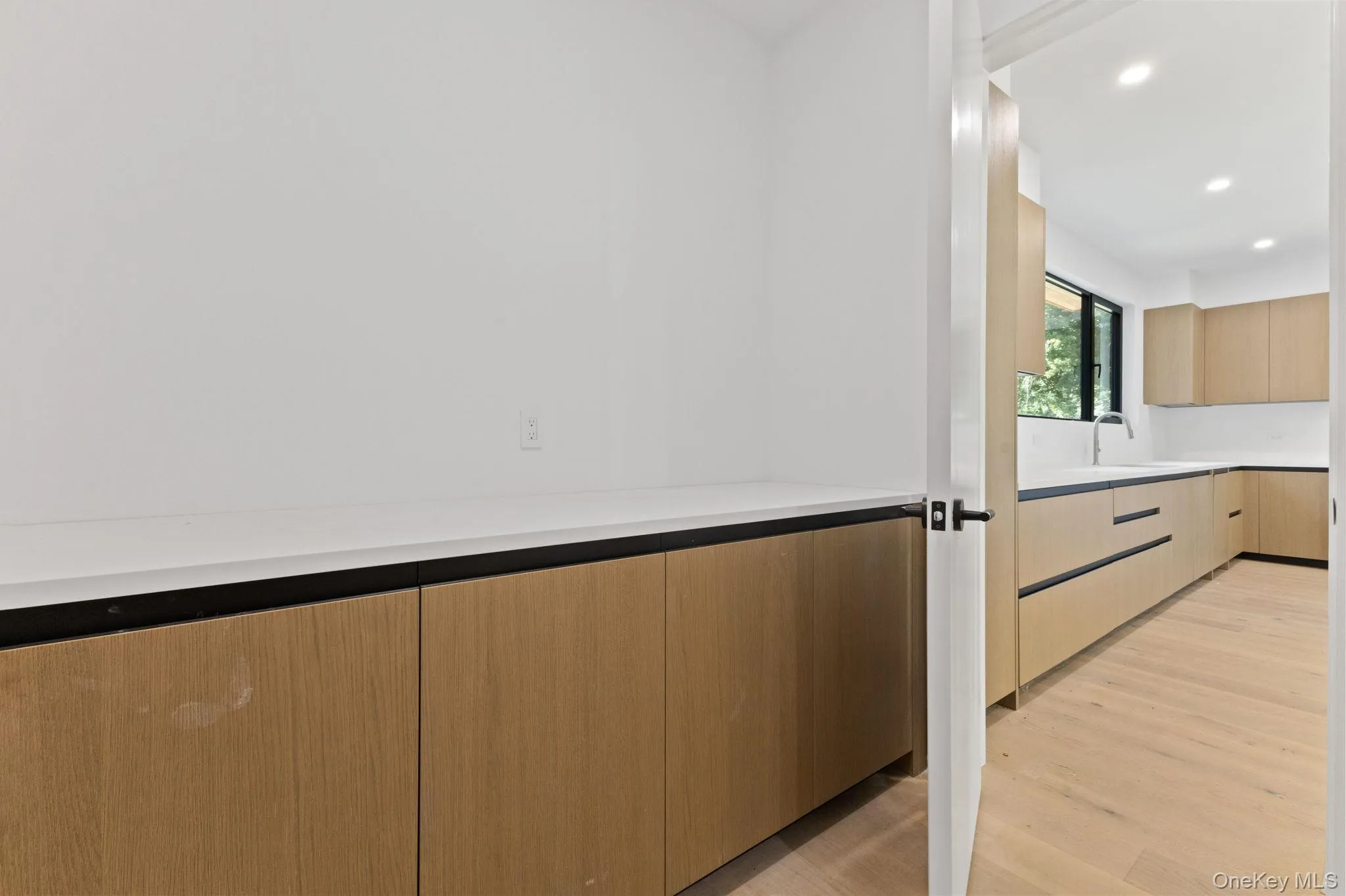 Kitchen featuring modern cabinets, light brown cabinetry, light wood-style floors, recessed lighting, and light stone countertops Kitchen featuring modern cabinets, light brown cabinetry, light wood-style floors, recessed lighting, and light stone countertops