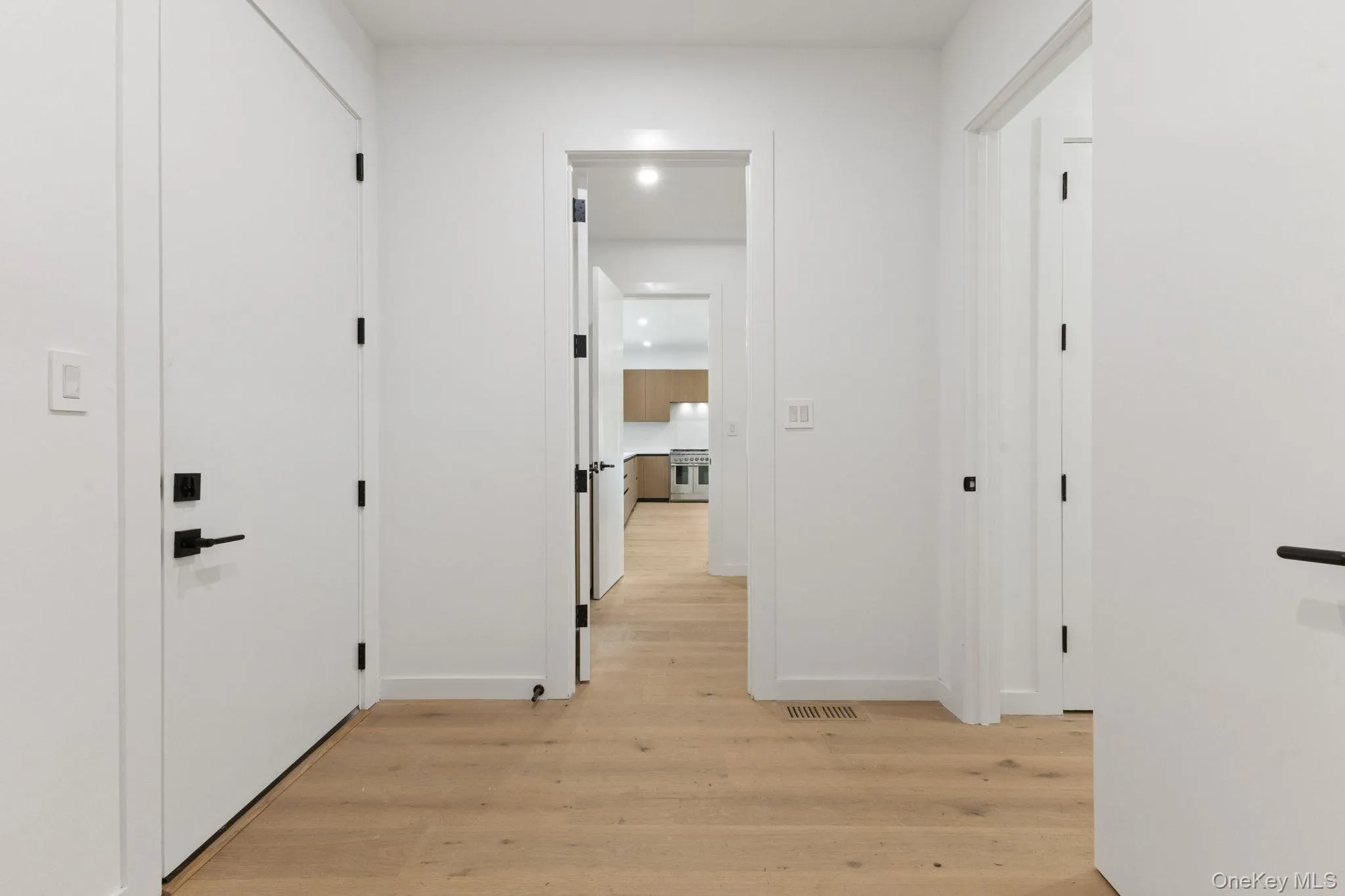 Hallway with light wood-style floors and baseboards Hallway with light wood-style floors and baseboards