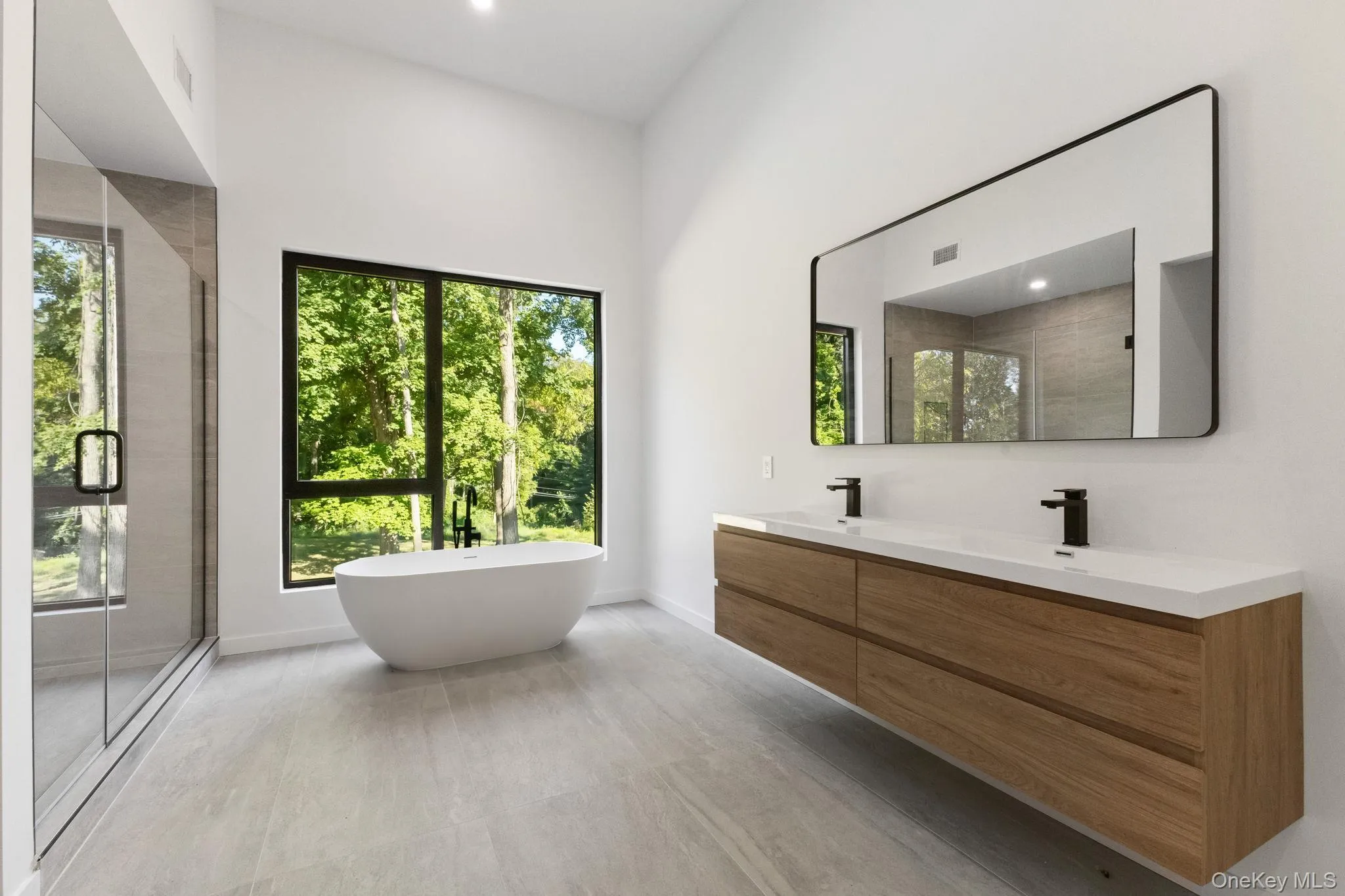 Bathroom featuring a freestanding tub, a shower stall, double vanity, and recessed lighting Bathroom featuring a freestanding tub, a shower stall, double vanity, and recessed lighting
