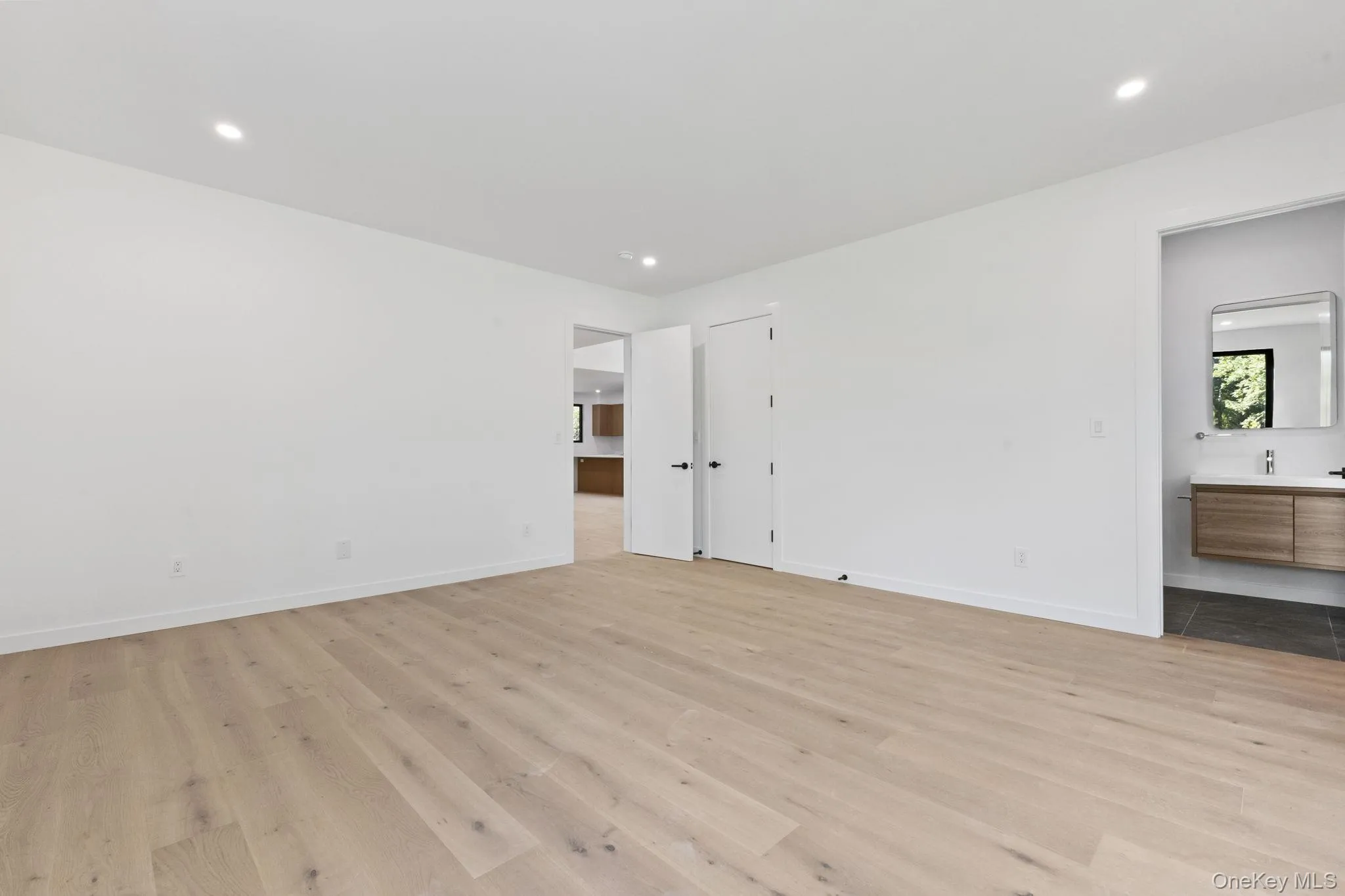 Unfurnished bedroom featuring light wood-style floors, recessed lighting, and connected bathroom Unfurnished bedroom featuring light wood-style floors, recessed lighting, and connected bathroom