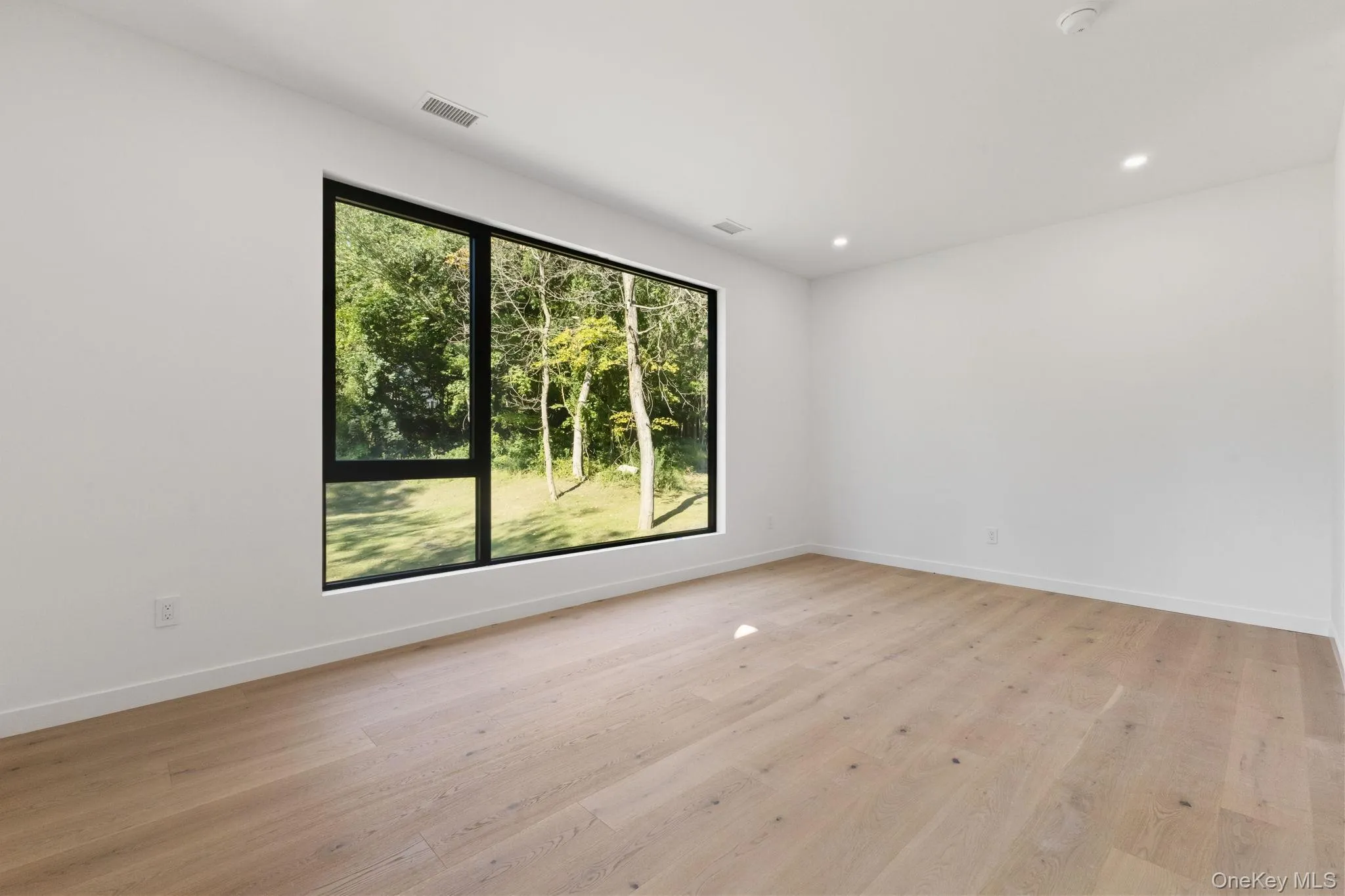 Empty room featuring light wood-type flooring and recessed lighting Empty room featuring light wood-type flooring and recessed lighting