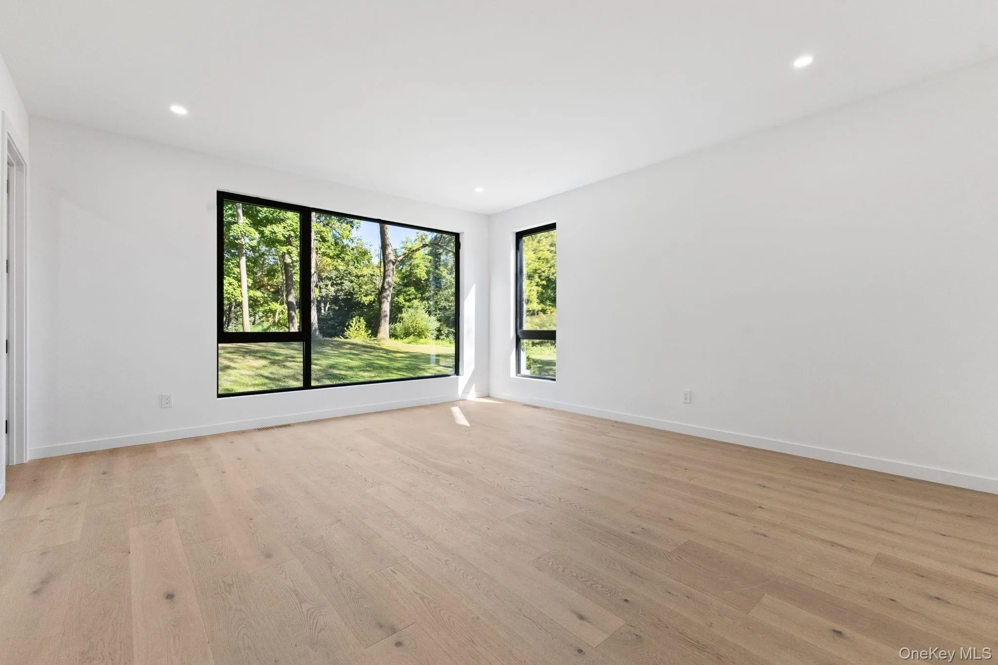 Empty room with light wood finished floors and recessed lighting Empty room with light wood finished floors and recessed lighting