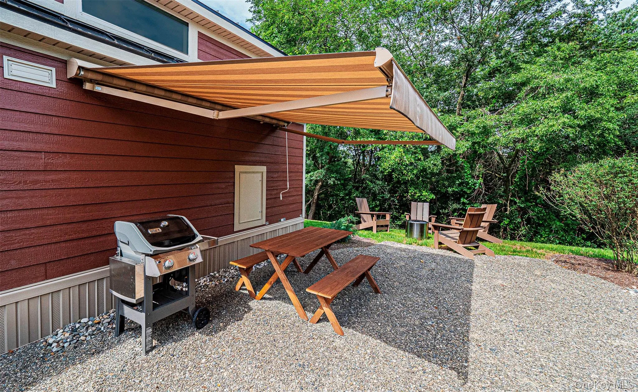 View of patio area with space to grill, and a picnic table, and awning. View of patio area with space to grill, and a picnic table, and awning.
