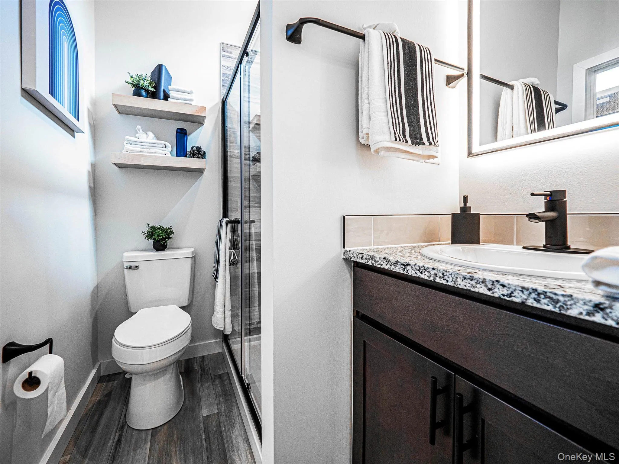 Full bathroom with vanity, a stall shower, and dark wood-type flooring Full bathroom with vanity, a stall shower, and dark wood-type flooring