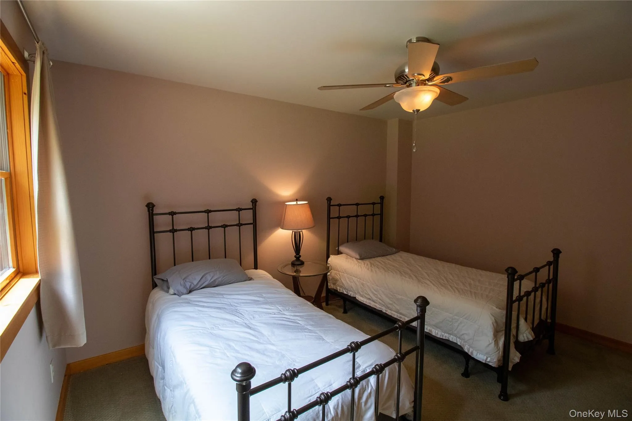 Bedroom with a ceiling fan and carpet floors Bedroom with a ceiling fan and carpet floors