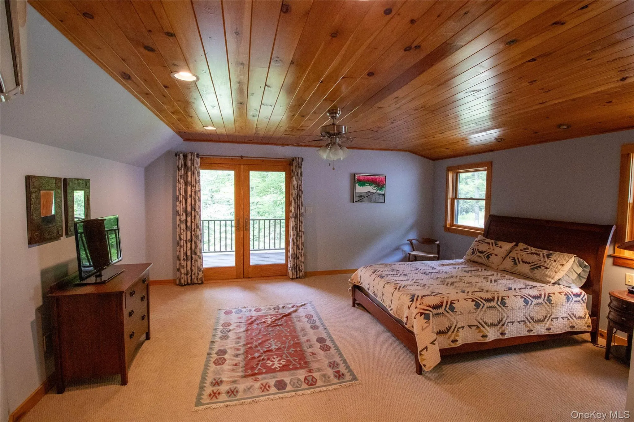 Bedroom featuring access to exterior, light colored carpet, lofted ceiling, wood ceiling, and ceiling fan Bedroom featuring access to exterior, light colored carpet, lofted ceiling, wood ceiling, and ceiling fan
