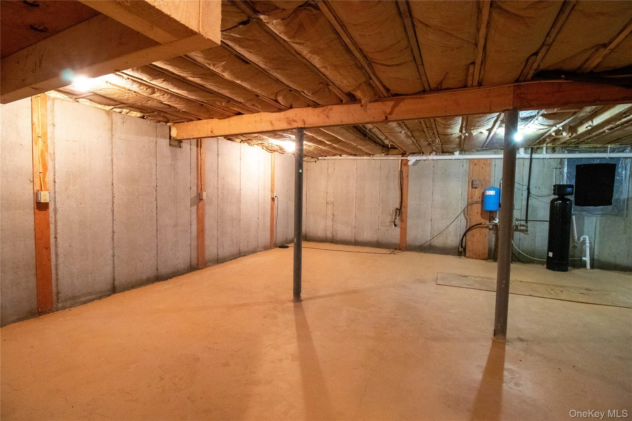 Unfinished basement with a water softener system Unfinished basement with a water softener system