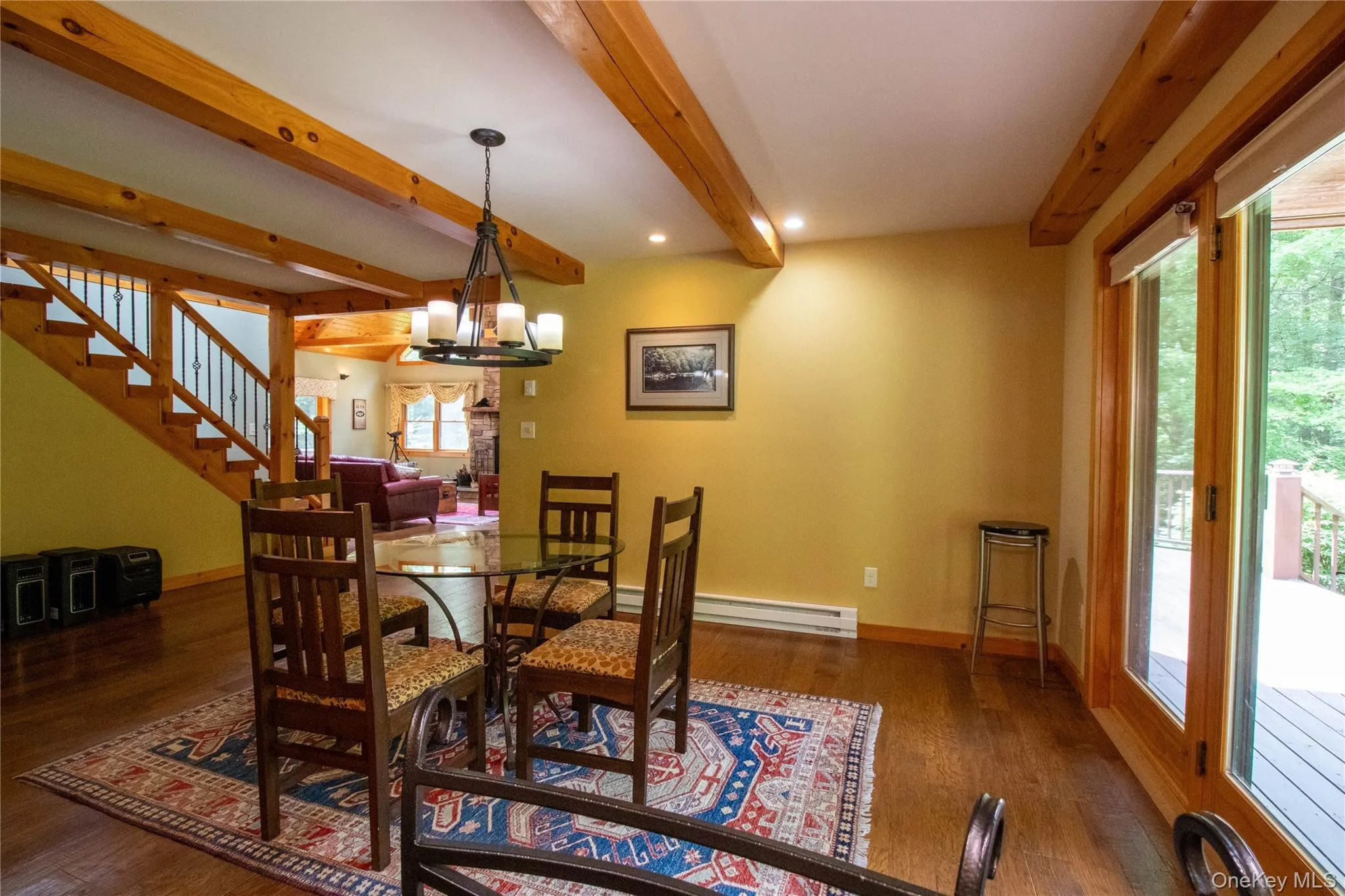 Dining space with a chandelier, dark wood-style flooring, stairs, beamed ceiling, and a baseboard heating unit Dining space with a chandelier, dark wood-style flooring, stairs, beamed ceiling, and a baseboard heating unit