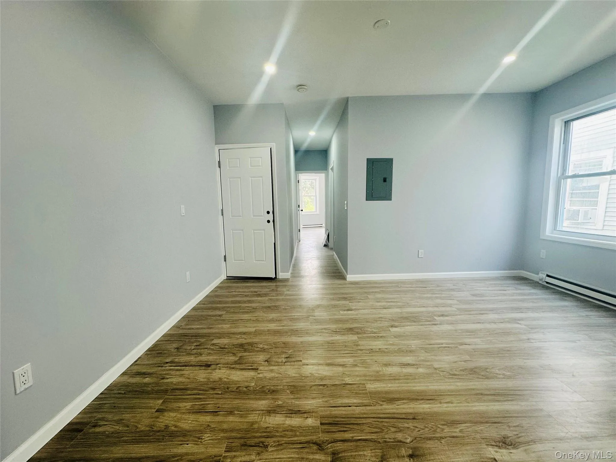 Spare room with wood finished floors and electric panel Spare room with wood finished floors and electric panel