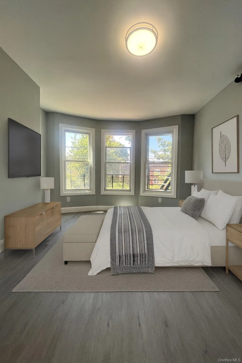 Bedroom featuring wood finished floors and multiple windows Bedroom featuring wood finished floors and multiple windows