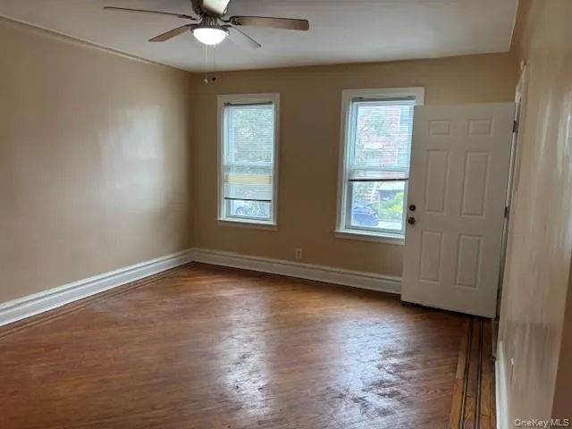 Empty room featuring dark wood-style floors and ceiling fan Empty room featuring dark wood-style floors and ceiling fan