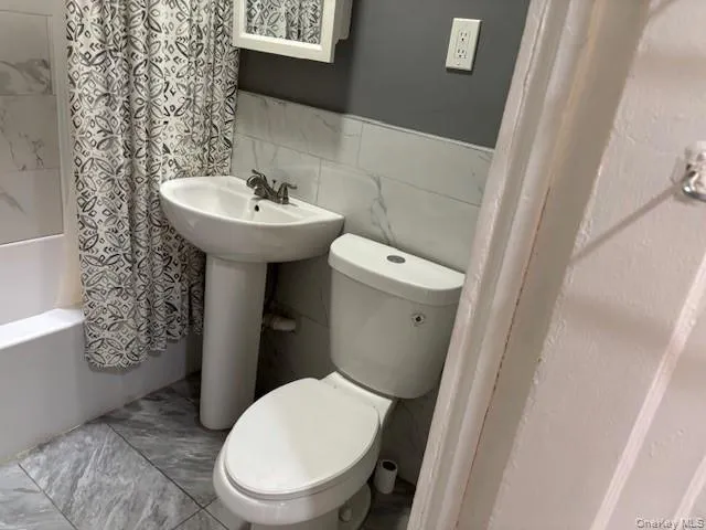 Full bath with tile walls and shower / bath combo Full bath with tile walls and shower / bath combo