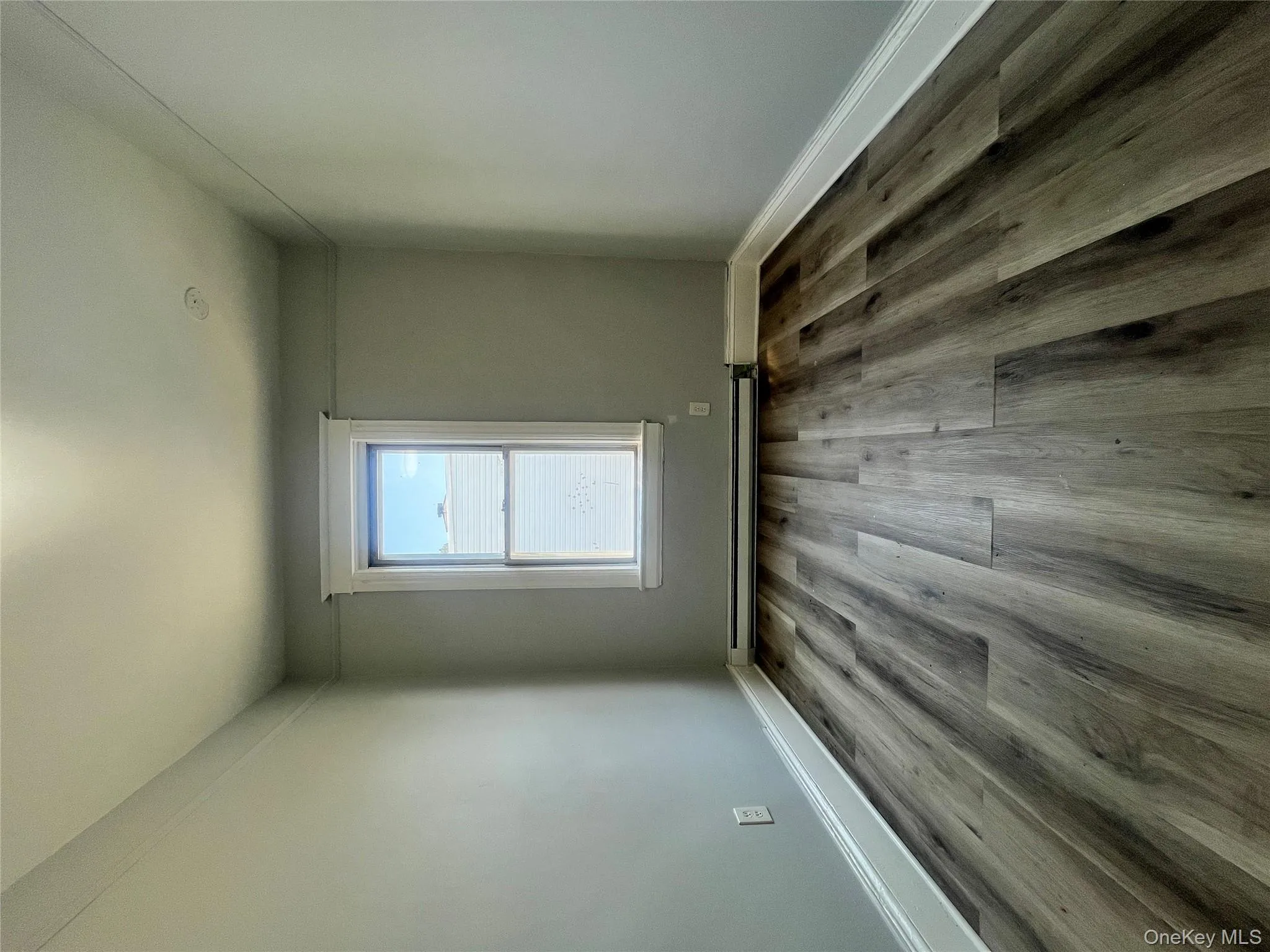 Spare room featuring dark wood-type flooring and a baseboard heating unit Spare room featuring dark wood-type flooring and a baseboard heating unit