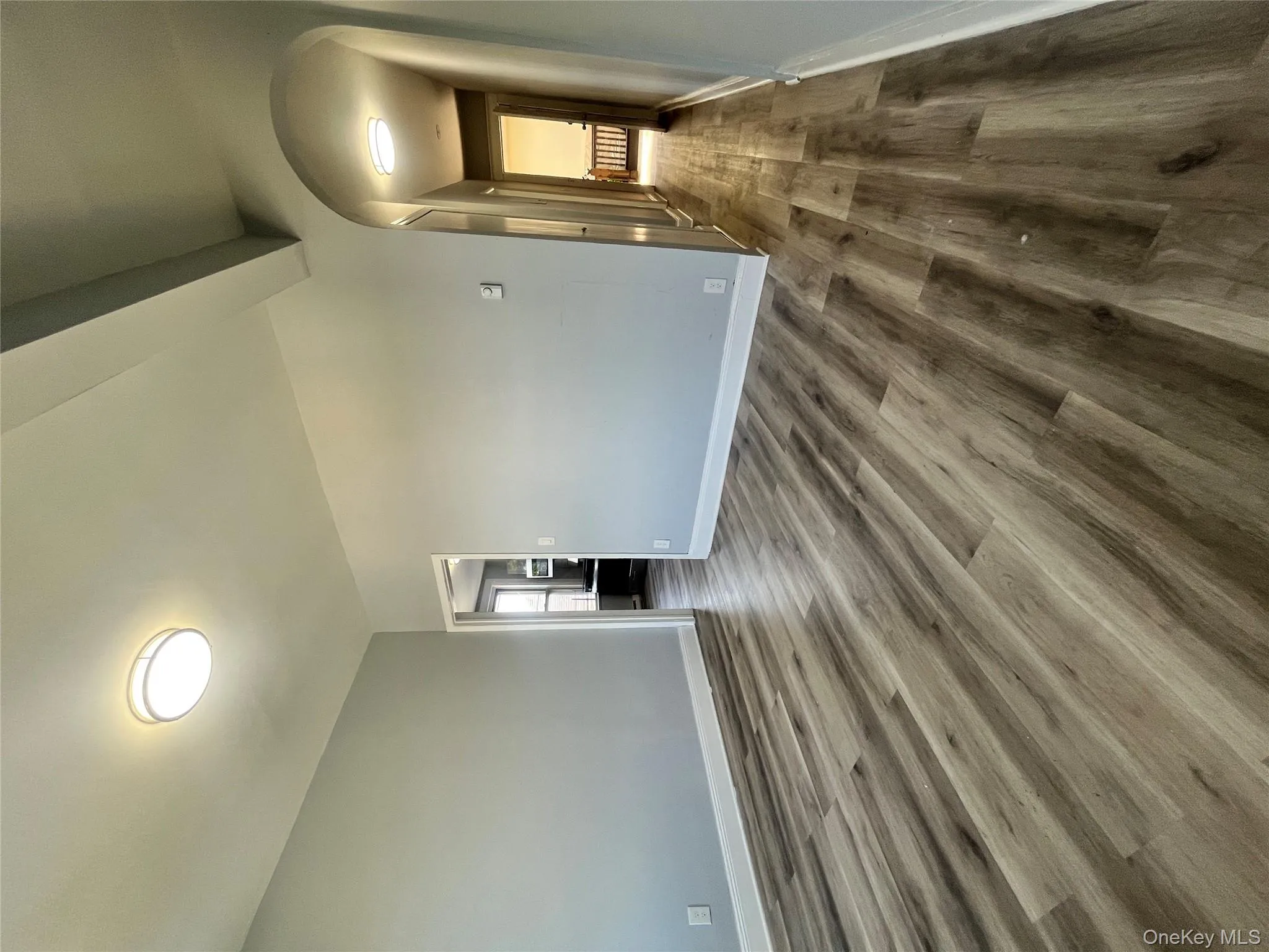 Spare room with dark wood-type flooring, beamed ceiling, and arched walkways Spare room with dark wood-type flooring, beamed ceiling, and arched walkways