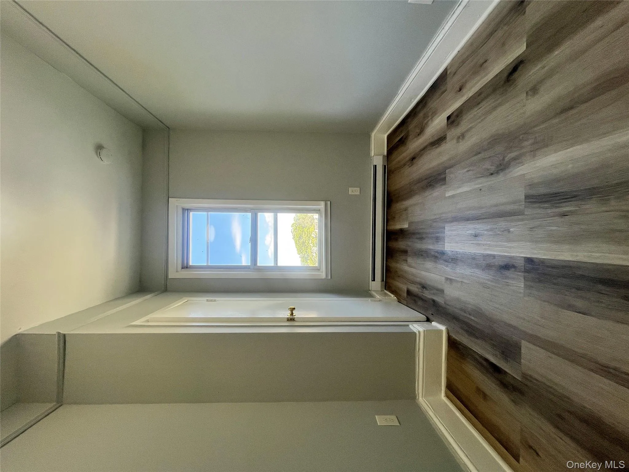 Unfurnished bedroom with dark wood-style flooring and a baseboard radiator Unfurnished bedroom with dark wood-style flooring and a baseboard radiator