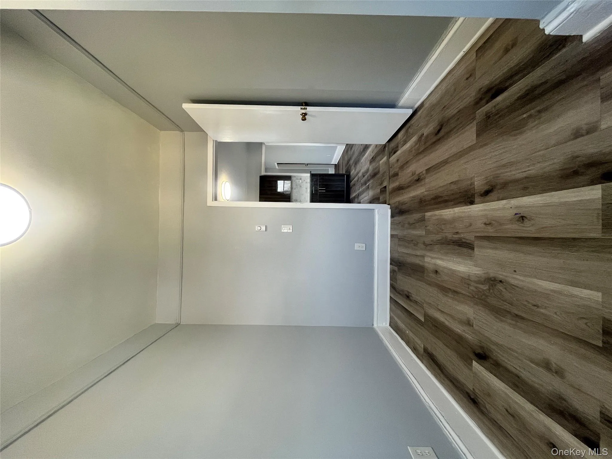 Empty room with dark wood-type flooring and baseboards Empty room with dark wood-type flooring and baseboards