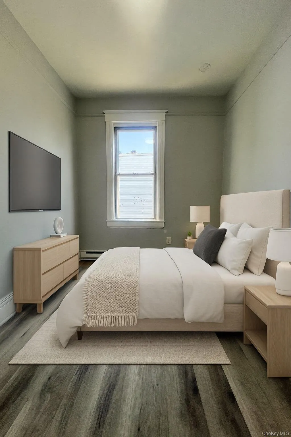 Bedroom with wood finished floors and a baseboard radiator Bedroom with wood finished floors and a baseboard radiator