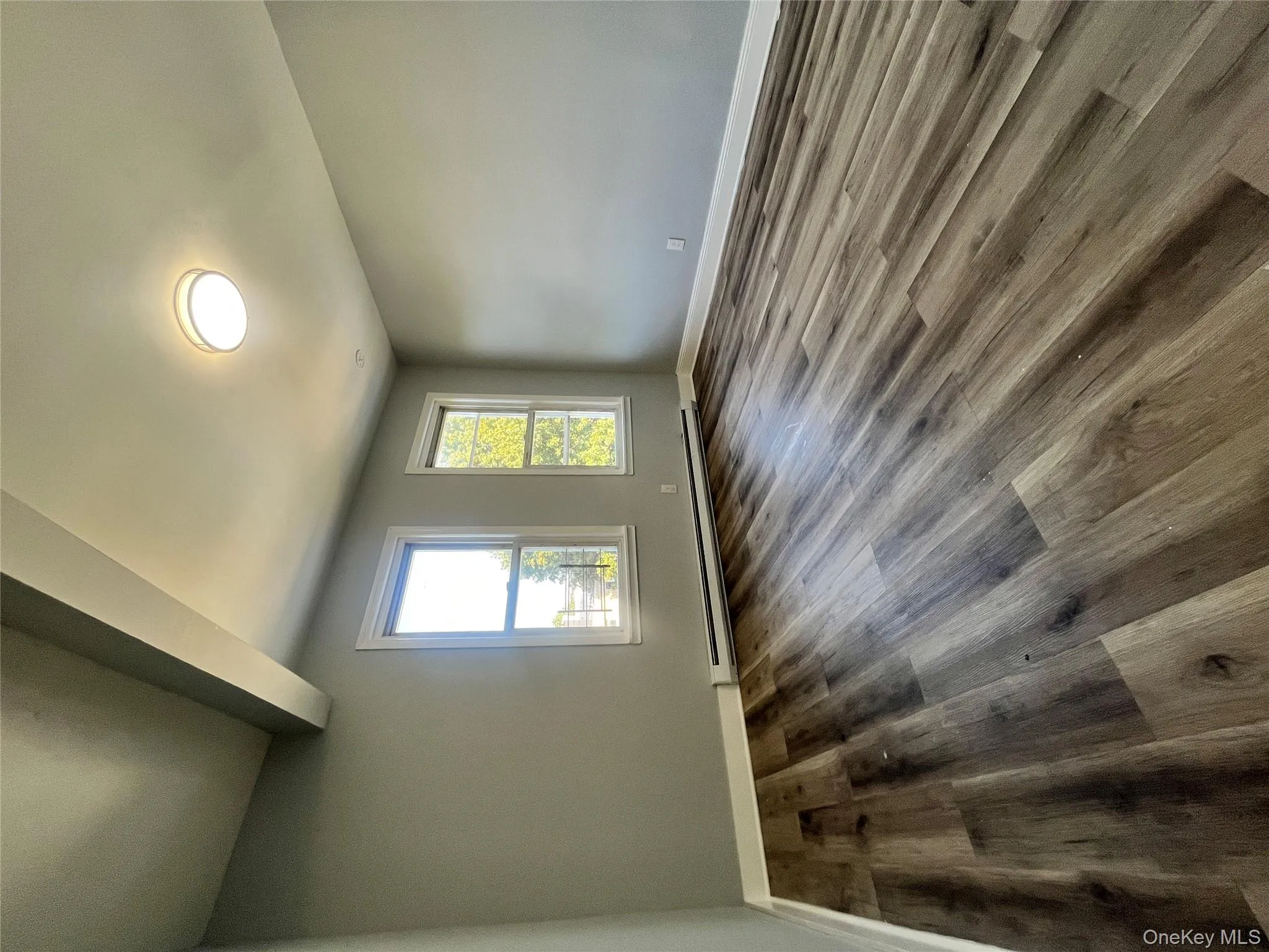 Unfurnished room with wood finished floors, baseboard heating, and beamed ceiling Unfurnished room with wood finished floors, baseboard heating, and beamed ceiling