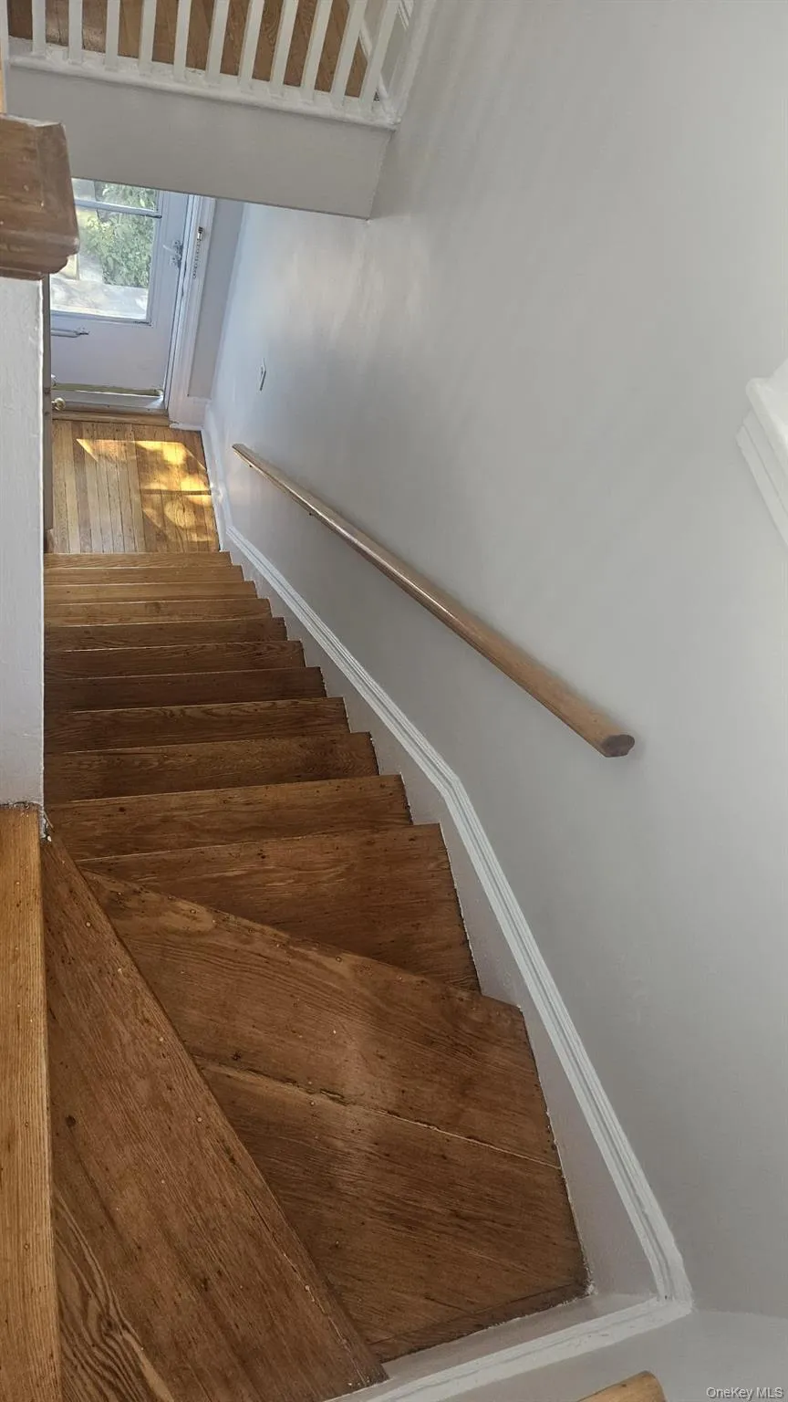 Staircase featuring baseboards and wood finished floors Staircase featuring baseboards and wood finished floors