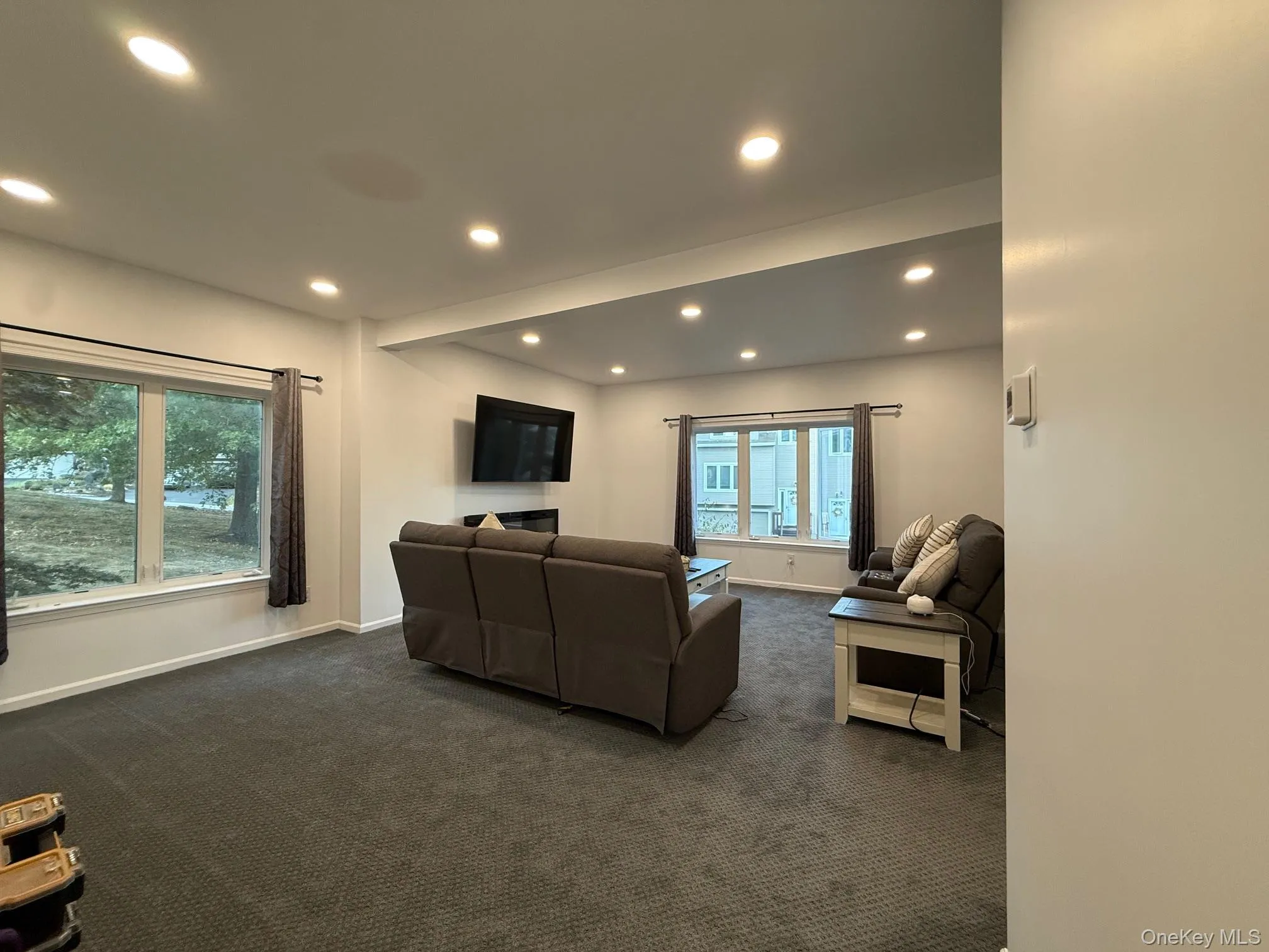 Living area featuring dark colored carpet and recessed lighting Living area featuring dark colored carpet and recessed lighting