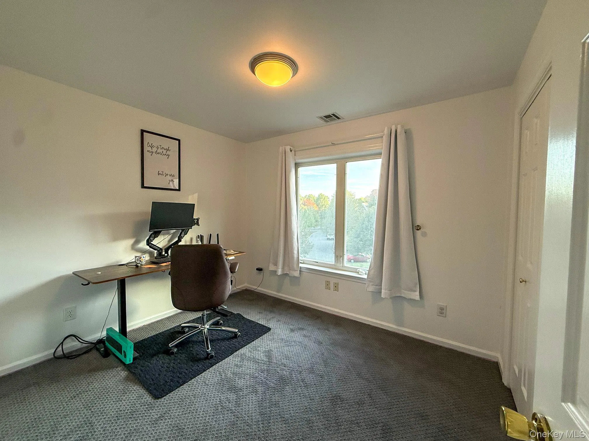 Office space with dark carpet and baseboards Office space with dark carpet and baseboards