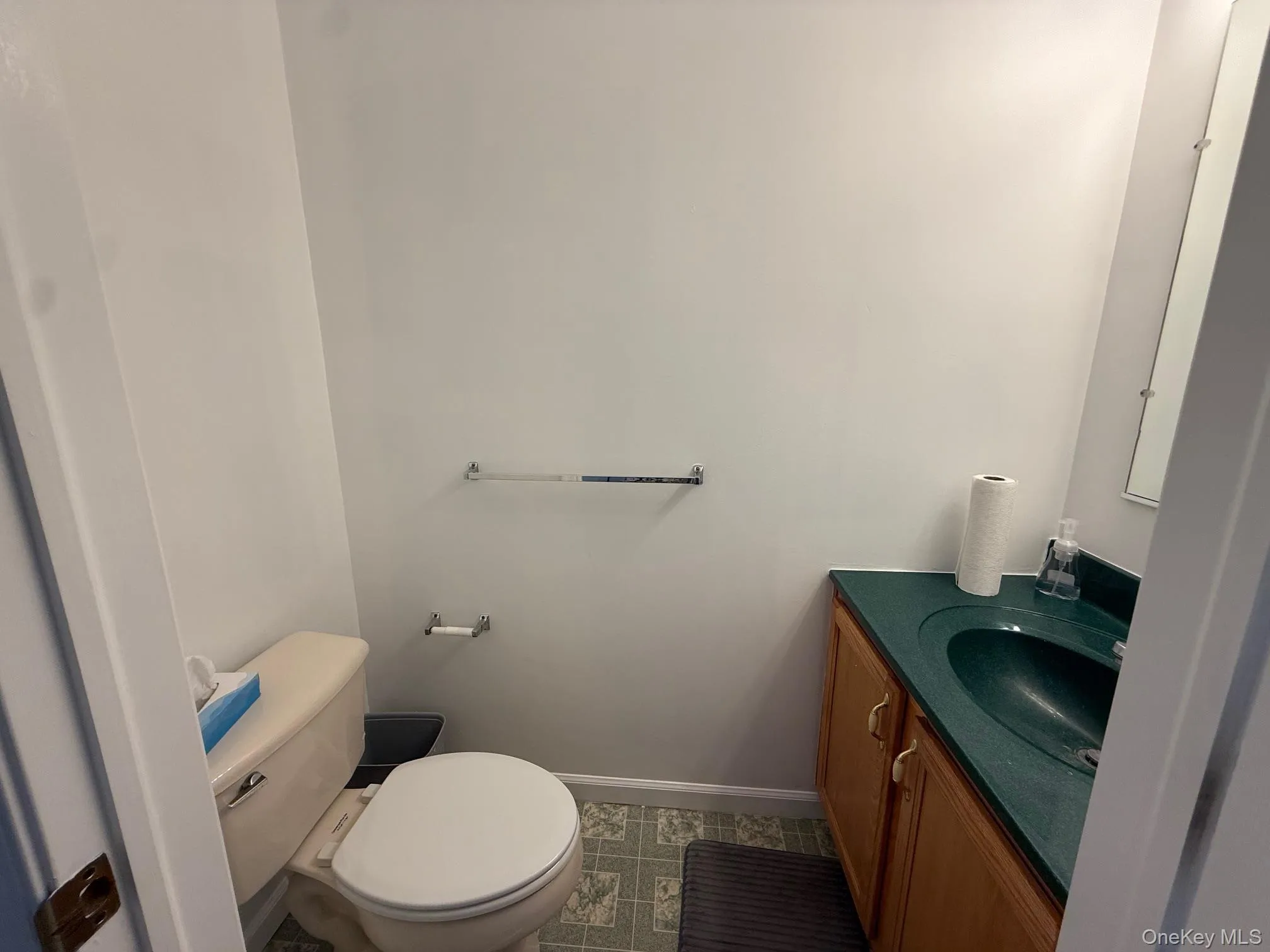 Half bath with vanity and dark tile patterned floors Half bath with vanity and dark tile patterned floors