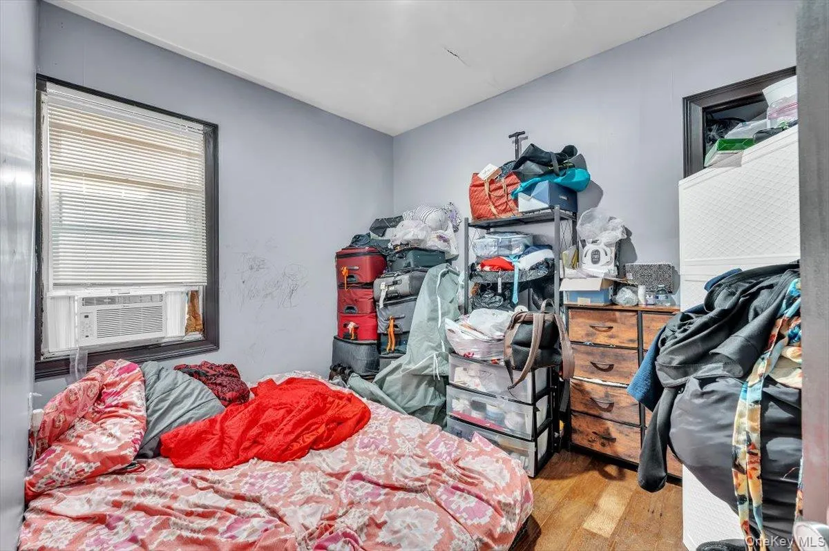 Bedroom with light wood-style floors and cooling unit Bedroom with light wood-style floors and cooling unit