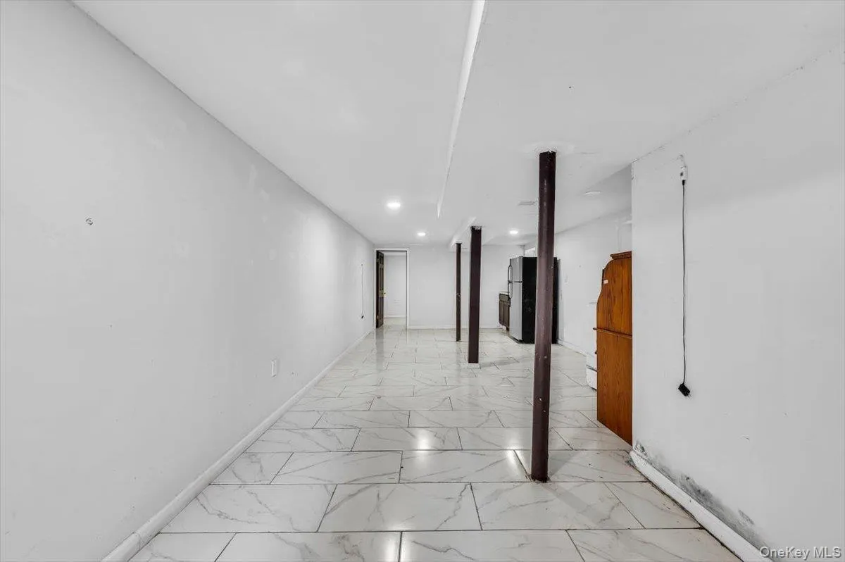 Hallway with light marble finish flooring and recessed lighting Hallway with light marble finish flooring and recessed lighting