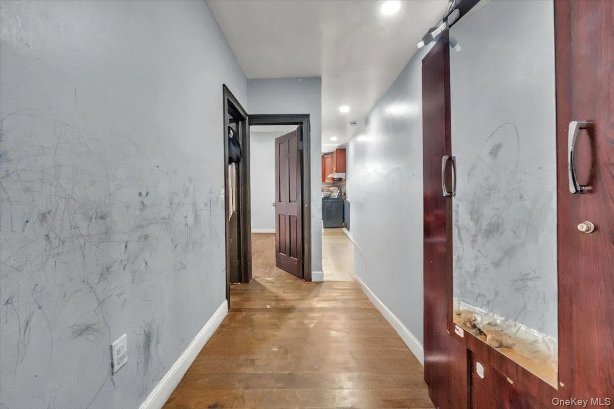 Corridor with wood-type flooring, recessed lighting, and a barn door Corridor with wood-type flooring, recessed lighting, and a barn door