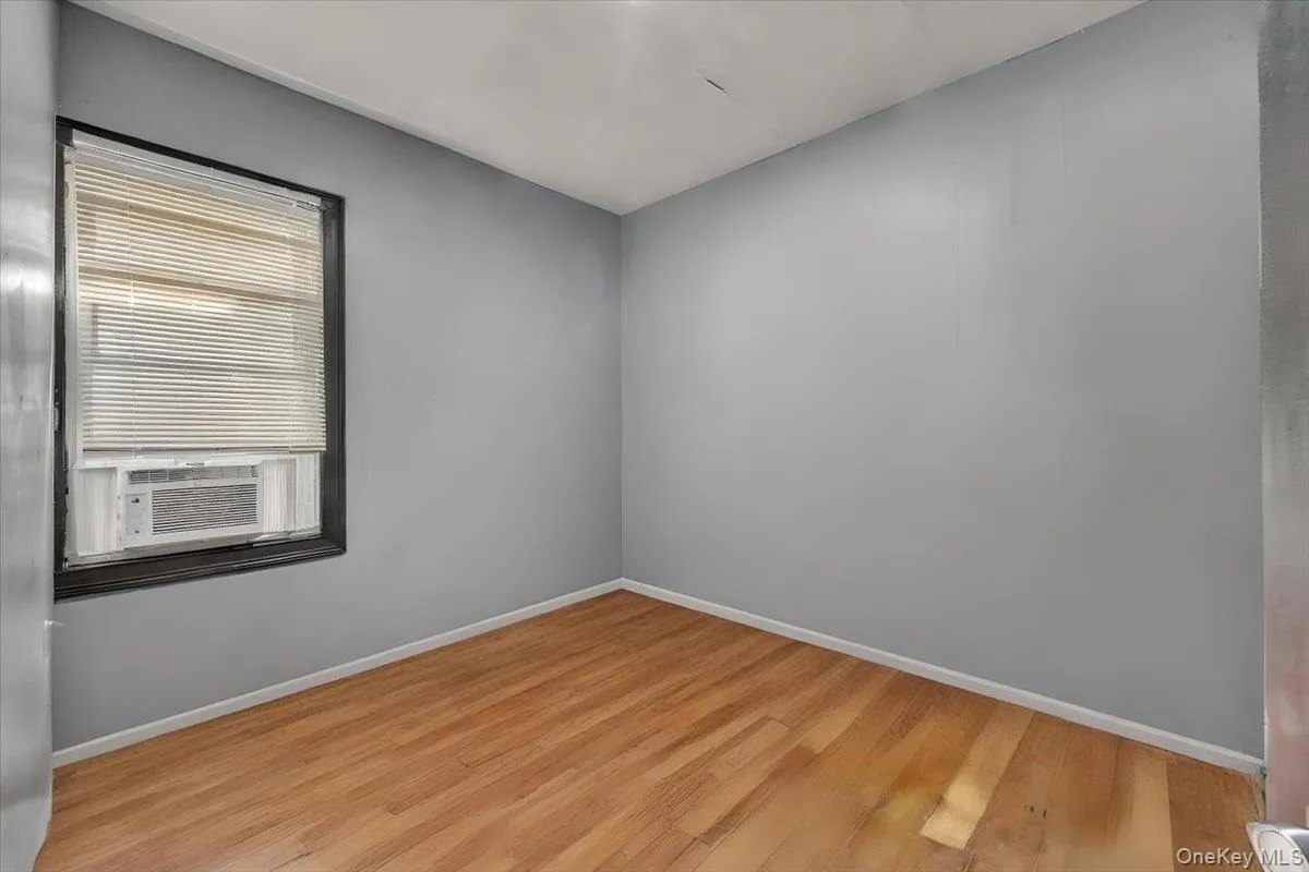 Unfurnished room featuring wood finished floors and cooling unit Unfurnished room featuring wood finished floors and cooling unit