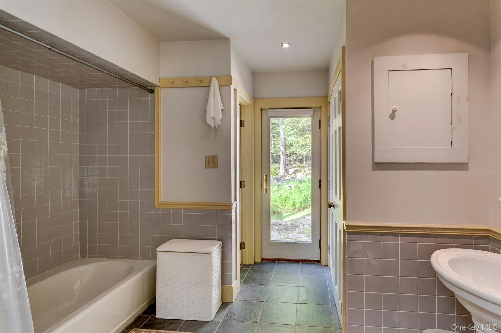 Bathroom with tile walls, a wainscoted wall, bathing tub / shower combination, and recessed lighting Bathroom with tile walls, a wainscoted wall, bathing tub / shower combination, and recessed lighting