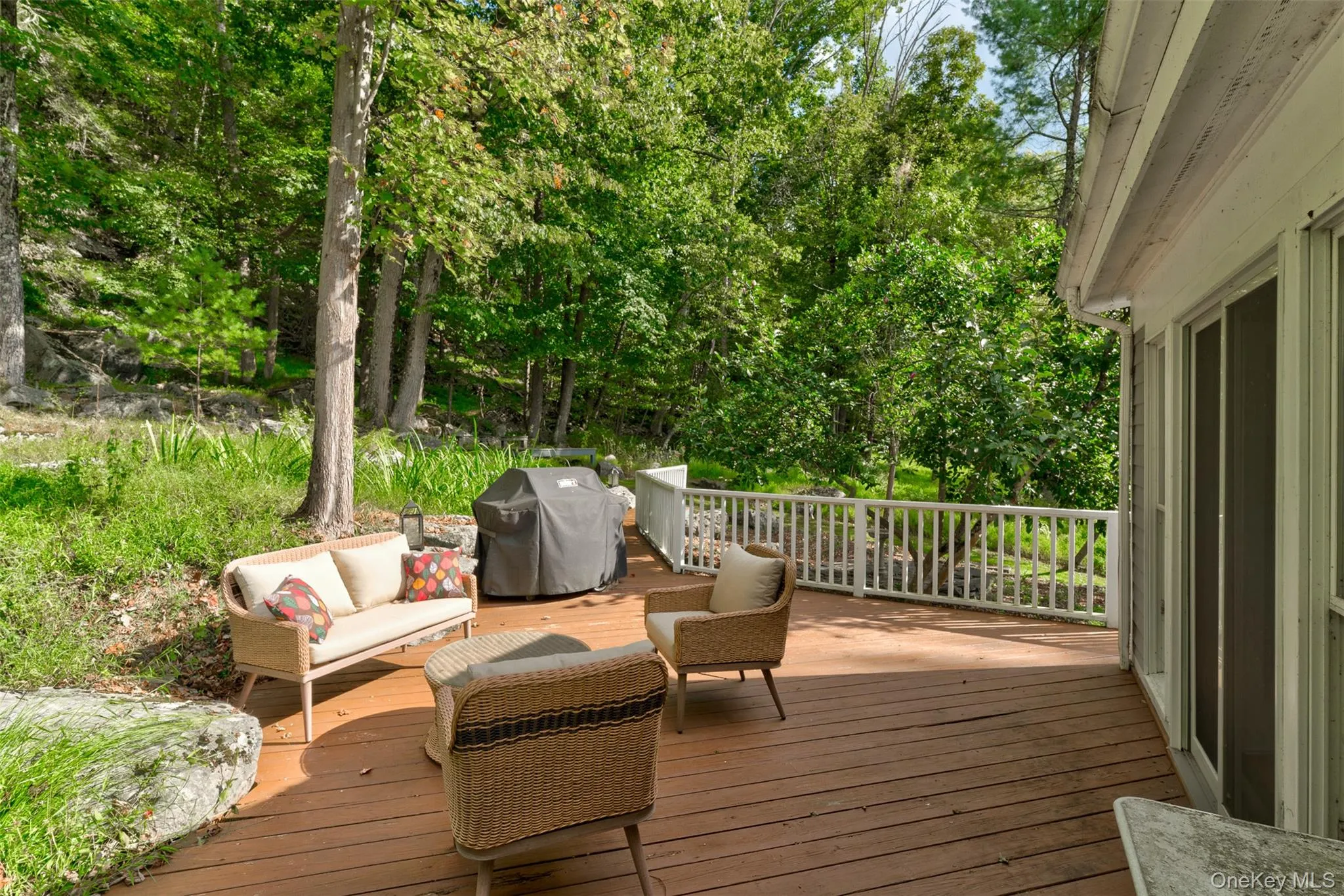 Deck with a grill, an outdoor hangout area, and view of wooded area Deck with a grill, an outdoor hangout area, and view of wooded area