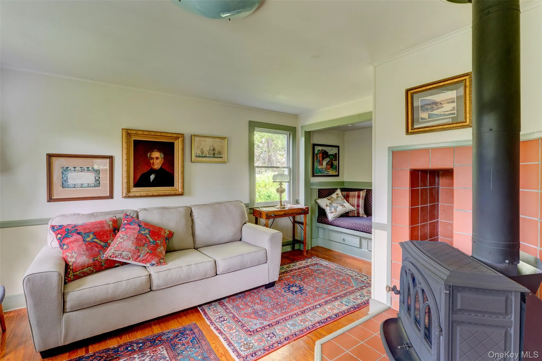 Living room featuring a wood stove and wood finished floors Living room featuring a wood stove and wood finished floors