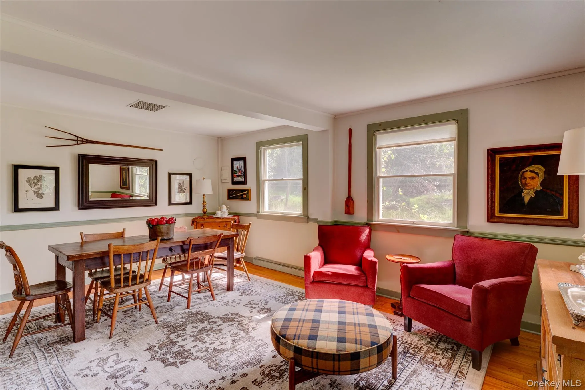 Living area with wood finished floors, a baseboard radiator, and ornamental molding Living area with wood finished floors, a baseboard radiator, and ornamental molding