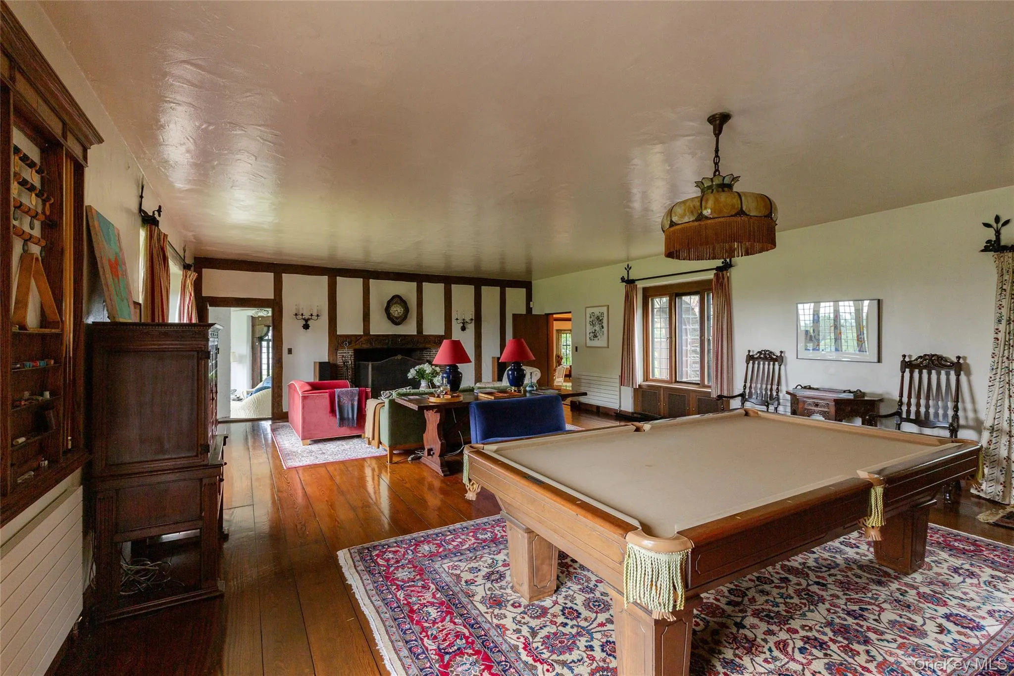 Recreation room with dark wood-style floors, billiards table, and a fireplace Recreation room with dark wood-style floors, billiards table, and a fireplace