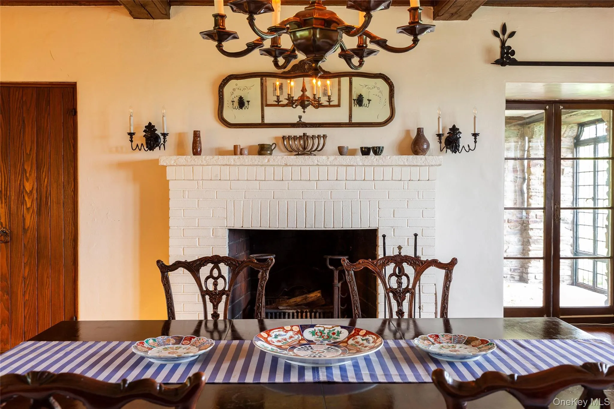 Dining space featuring a brick fireplace and a chandelier Dining space featuring a brick fireplace and a chandelier