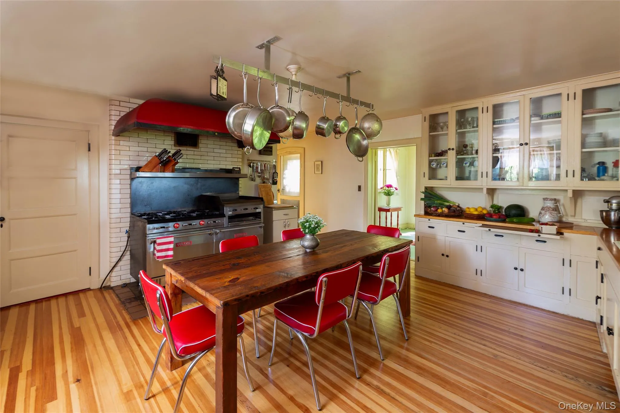 Dining area featuring light wood-style flooring and brick wall Dining area featuring light wood-style flooring and brick wall