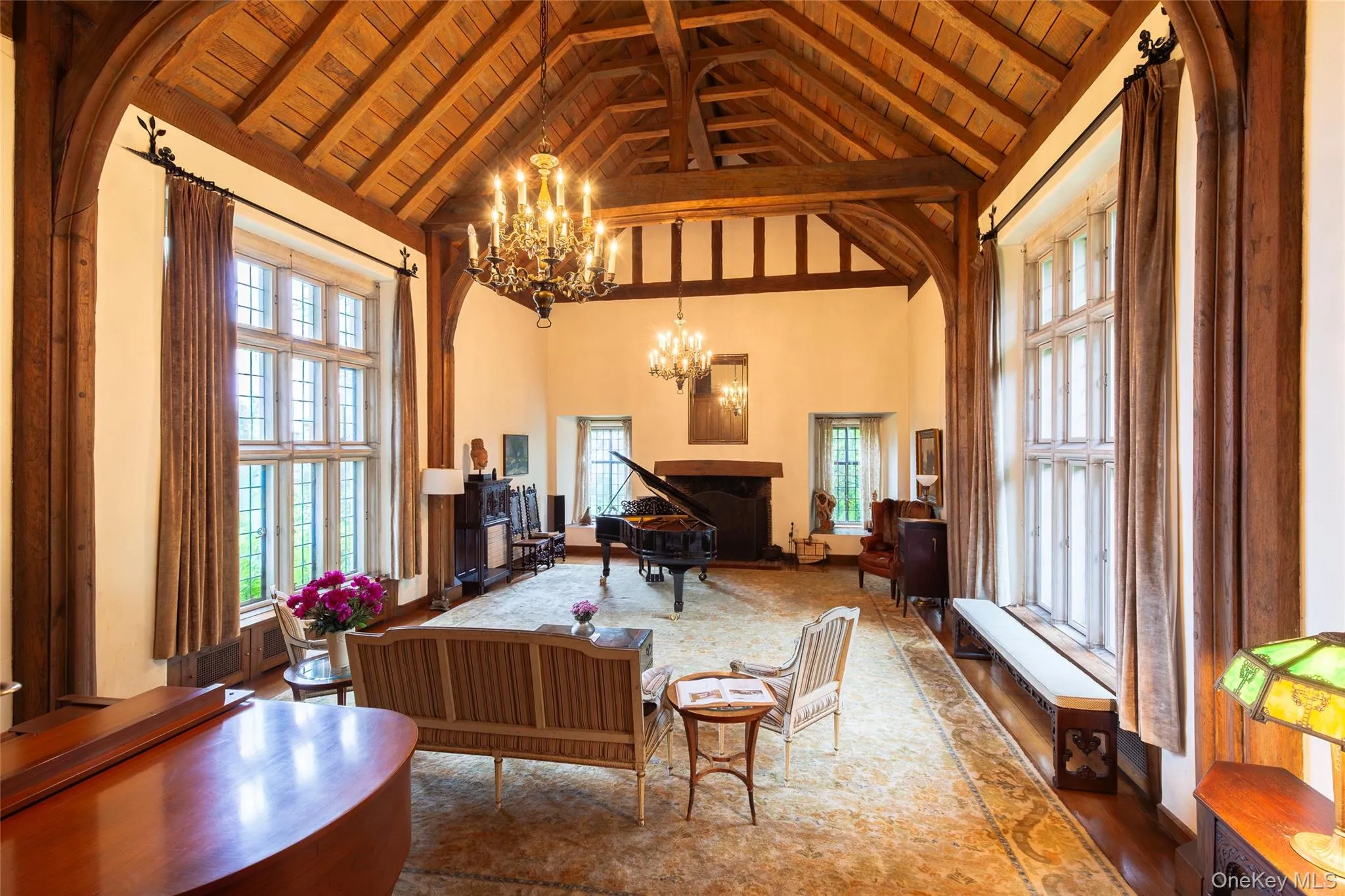 Sitting room featuring high vaulted ceiling, a wood ceiling with exposed beams, arched walkways, and a chandelier Sitting room featuring high vaulted ceiling, a wood ceiling with exposed beams, arched walkways, and a chandelier