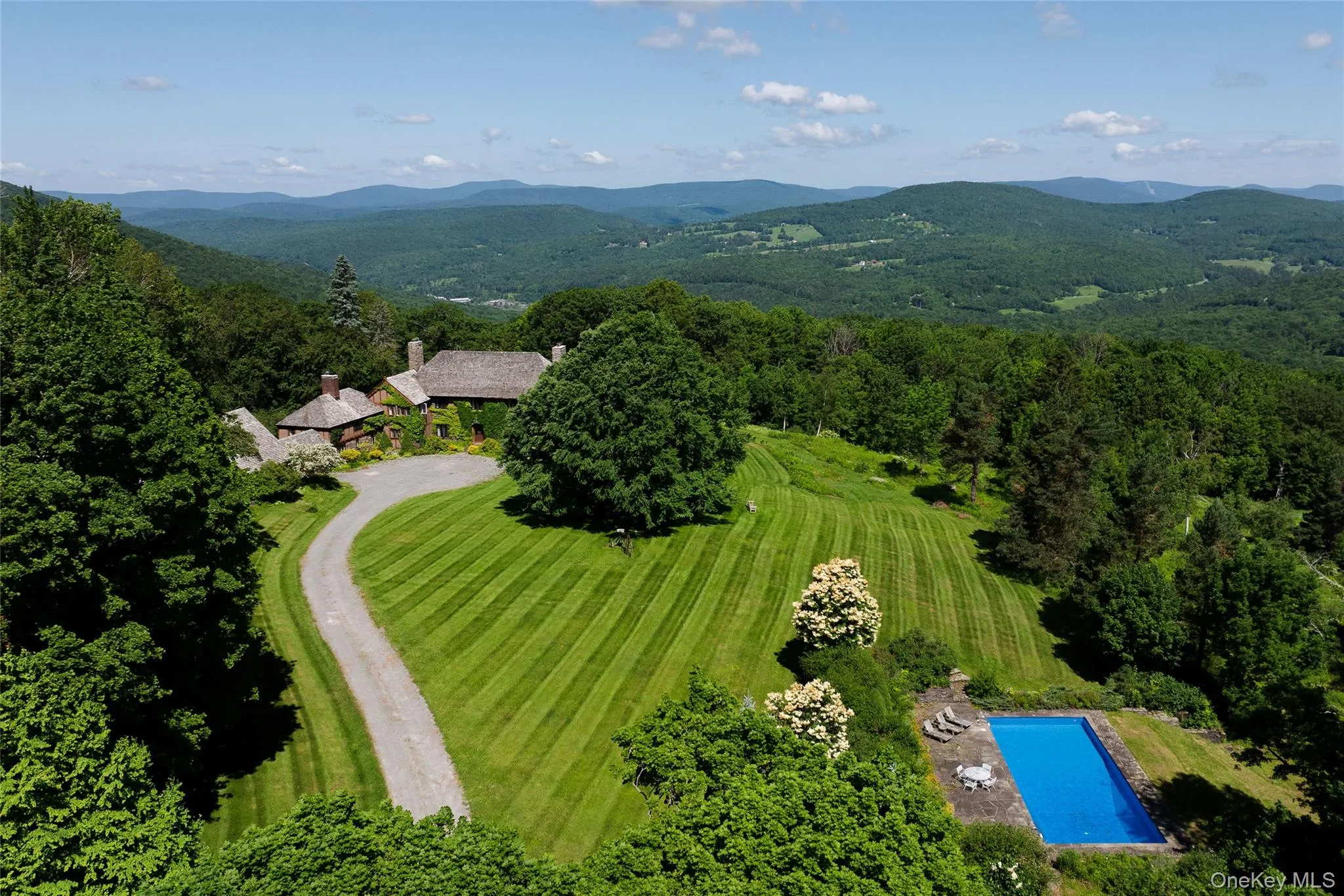 Drone / aerial view of a mountainous background and a pool area Drone / aerial view of a mountainous background and a pool area