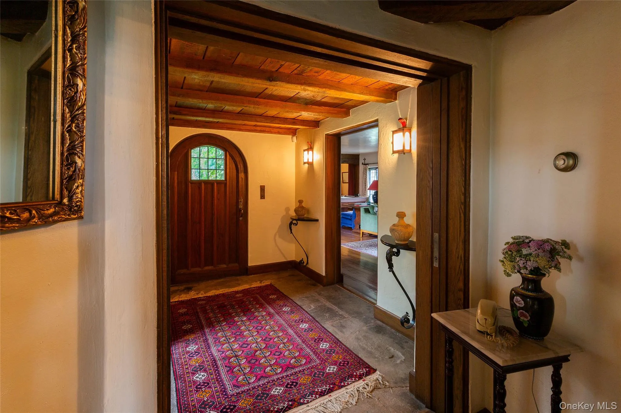 Foyer entrance with a wooden ceiling with exposed beams and arched walkways Foyer entrance with a wooden ceiling with exposed beams and arched walkways