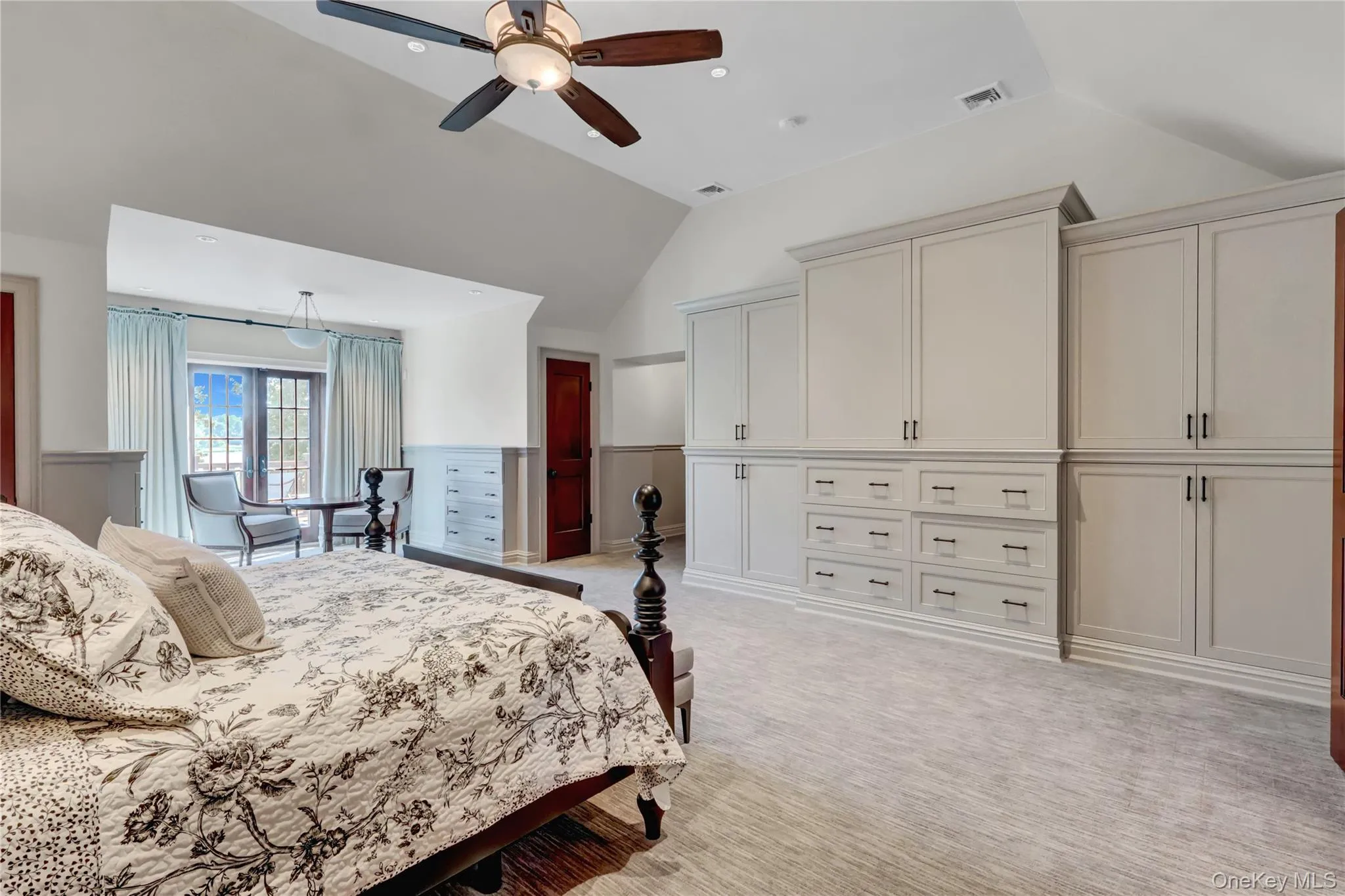 Bedroom featuring vaulted ceiling, light carpet, and a ceiling fan Bedroom featuring vaulted ceiling, light carpet, and a ceiling fan