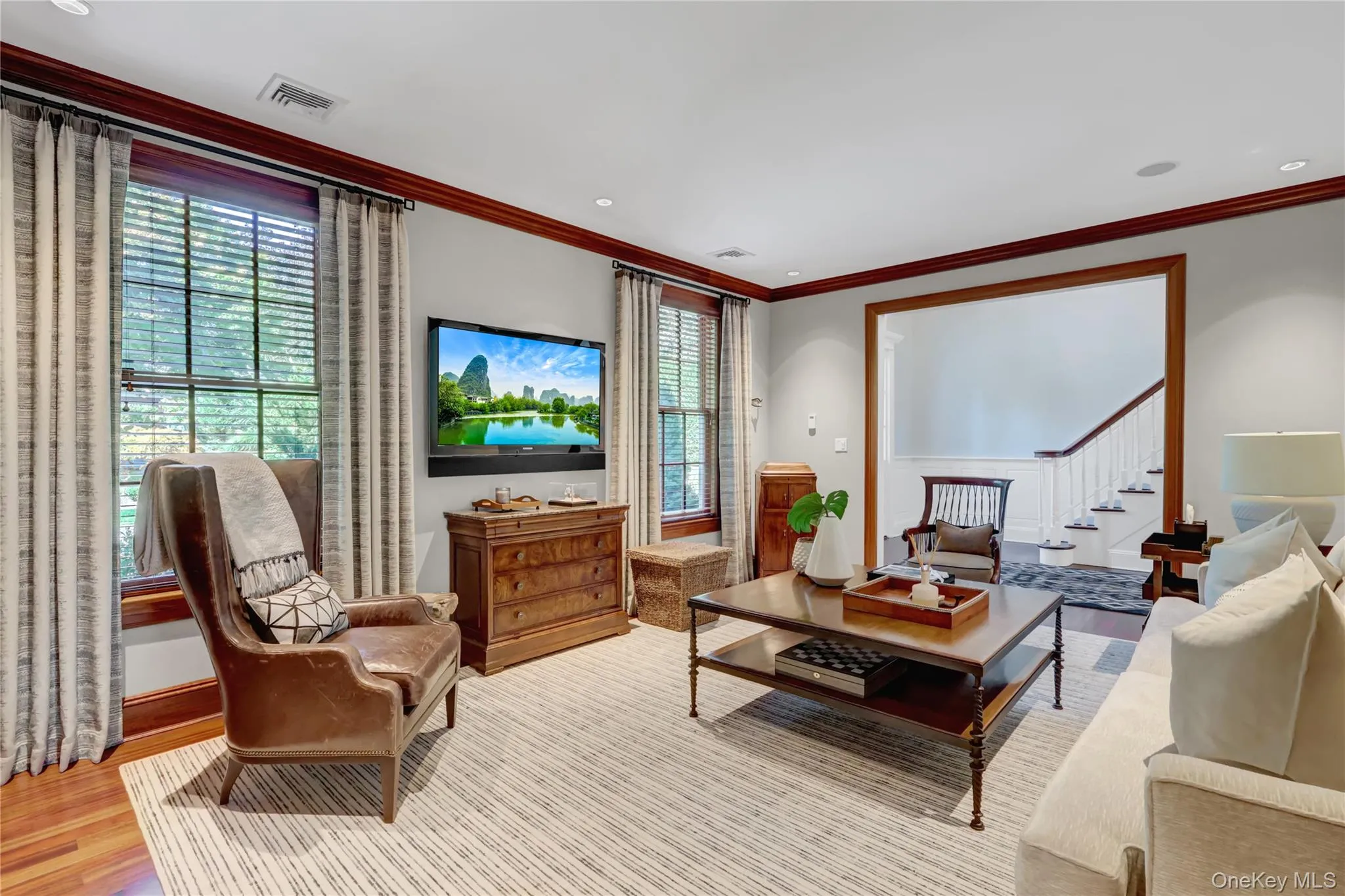 Living area with light wood-style flooring, crown molding, stairway, and recessed lighting Living area with light wood-style flooring, crown molding, stairway, and recessed lighting