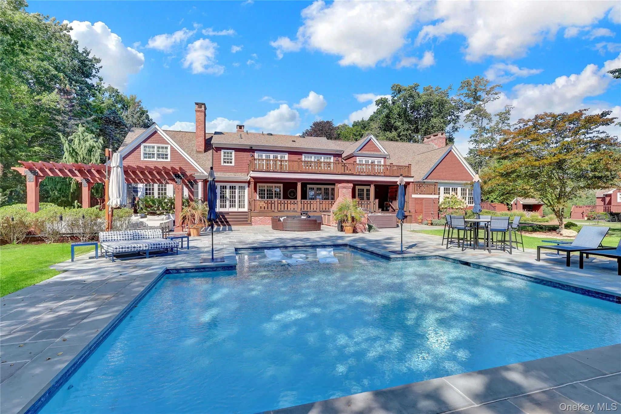 Swimming pool with a patio, a pergola, and a hot tub Swimming pool with a patio, a pergola, and a hot tub