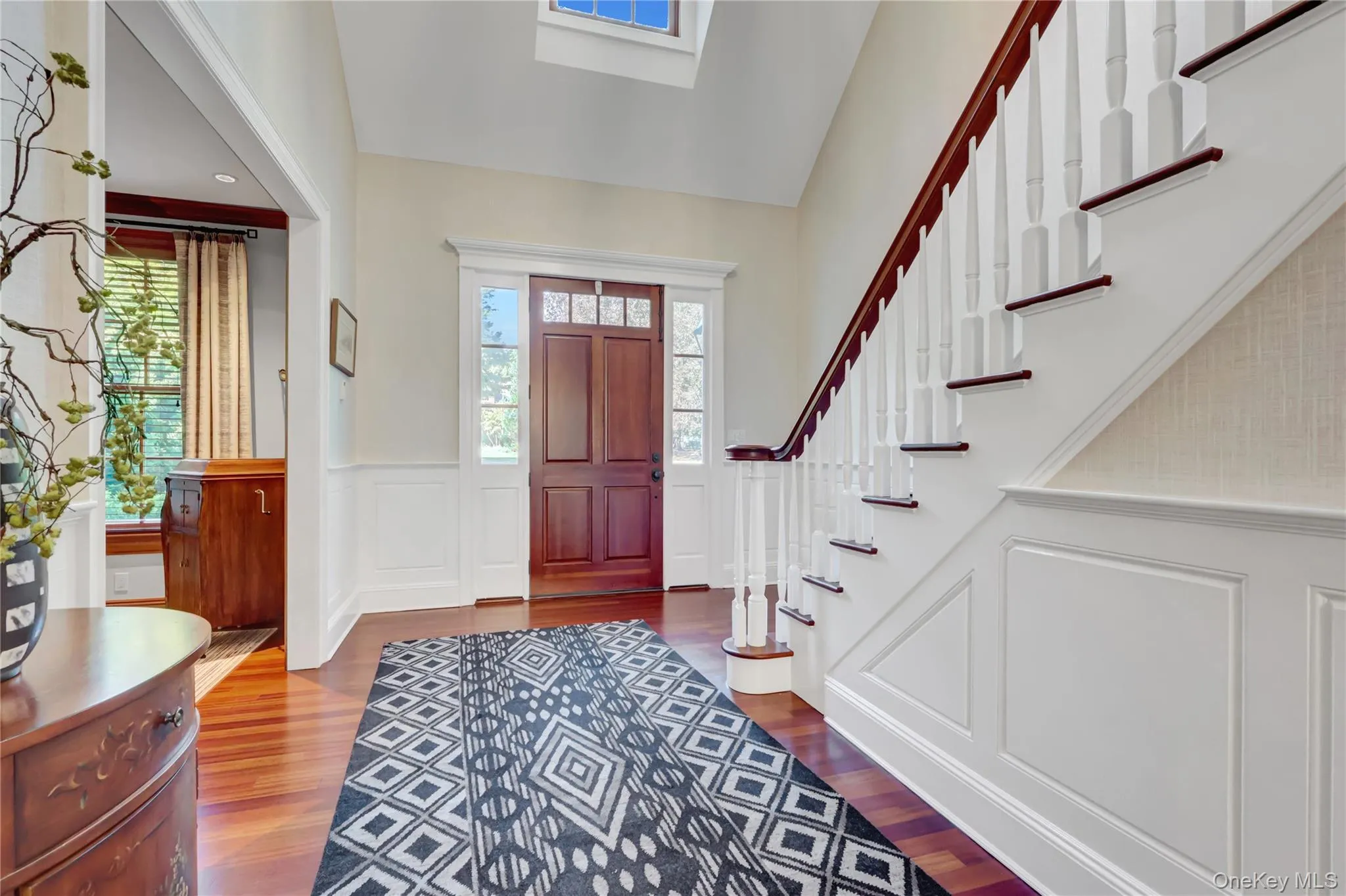 Foyer featuring a wainscoted wall, a decorative wall, and wood finished floors Foyer featuring a wainscoted wall, a decorative wall, and wood finished floors