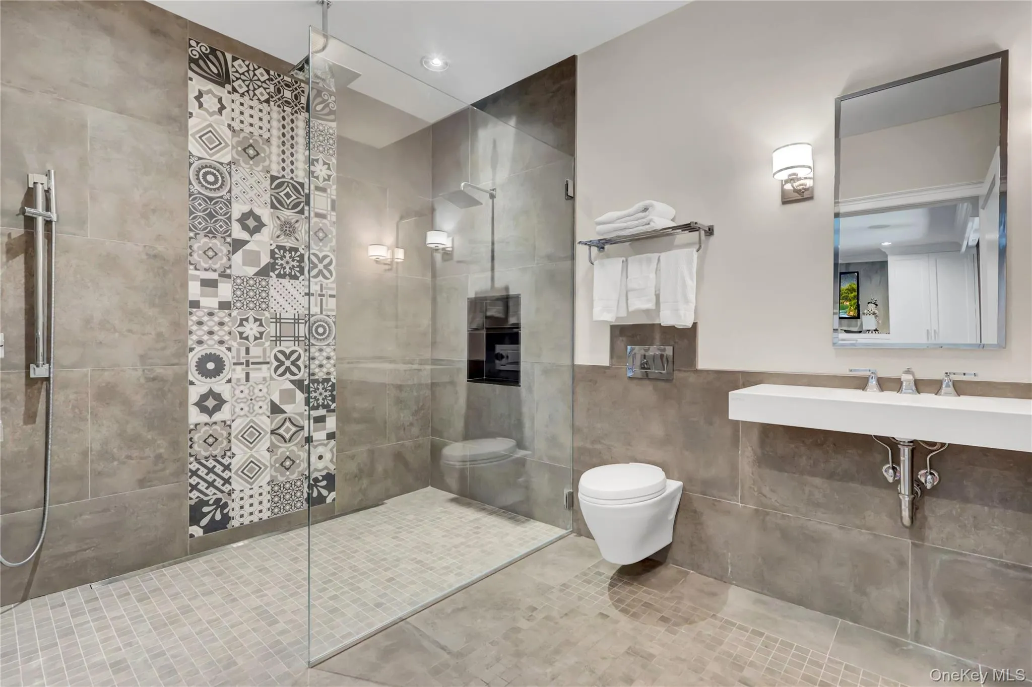 Bathroom featuring walk in shower, tile walls, tile patterned floors, and a wainscoted wall Bathroom featuring walk in shower, tile walls, tile patterned floors, and a wainscoted wall