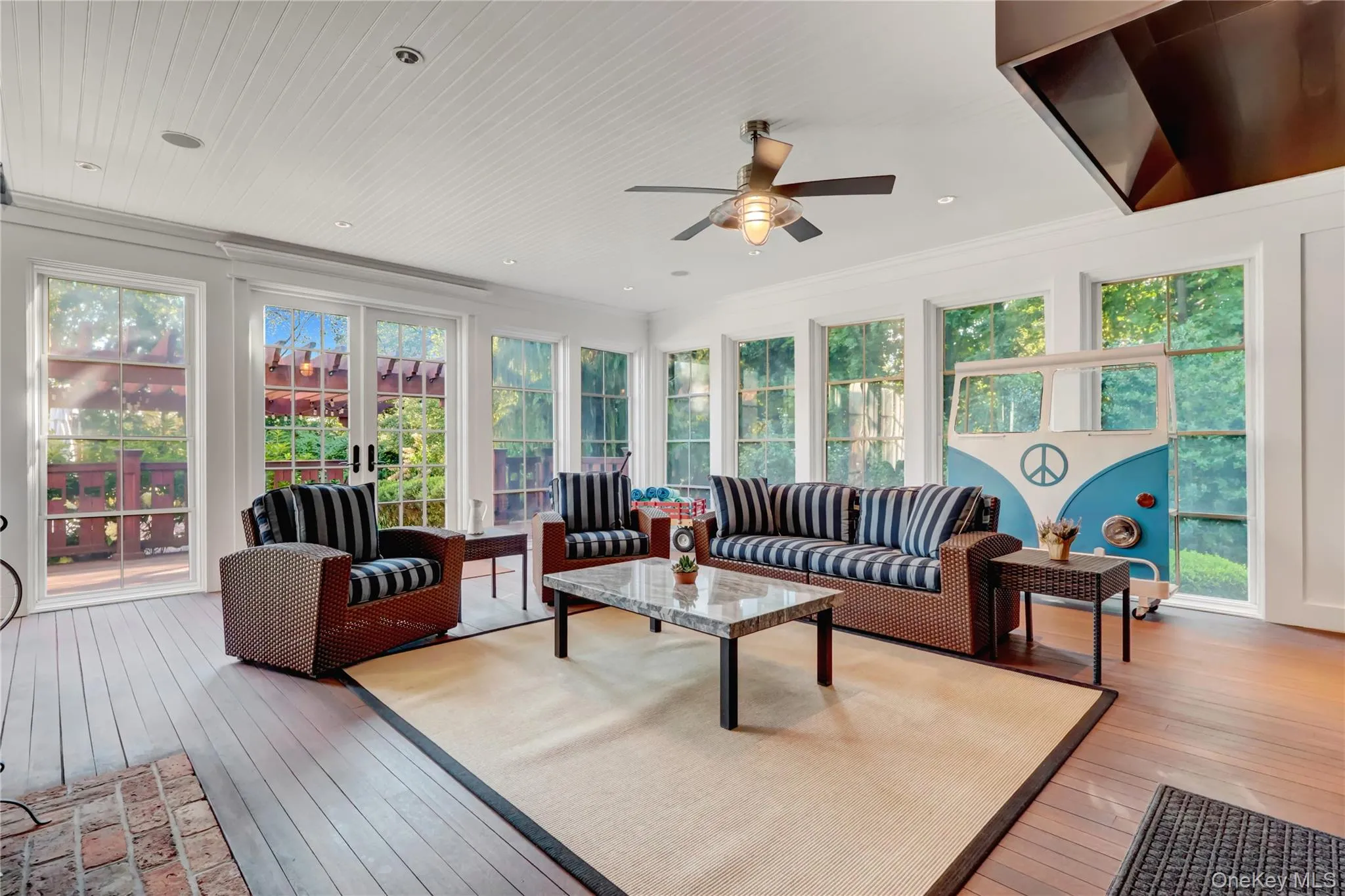 Sunroom / solarium featuring hardwood / wood-style floors and ornamental molding Sunroom / solarium featuring hardwood / wood-style floors and ornamental molding