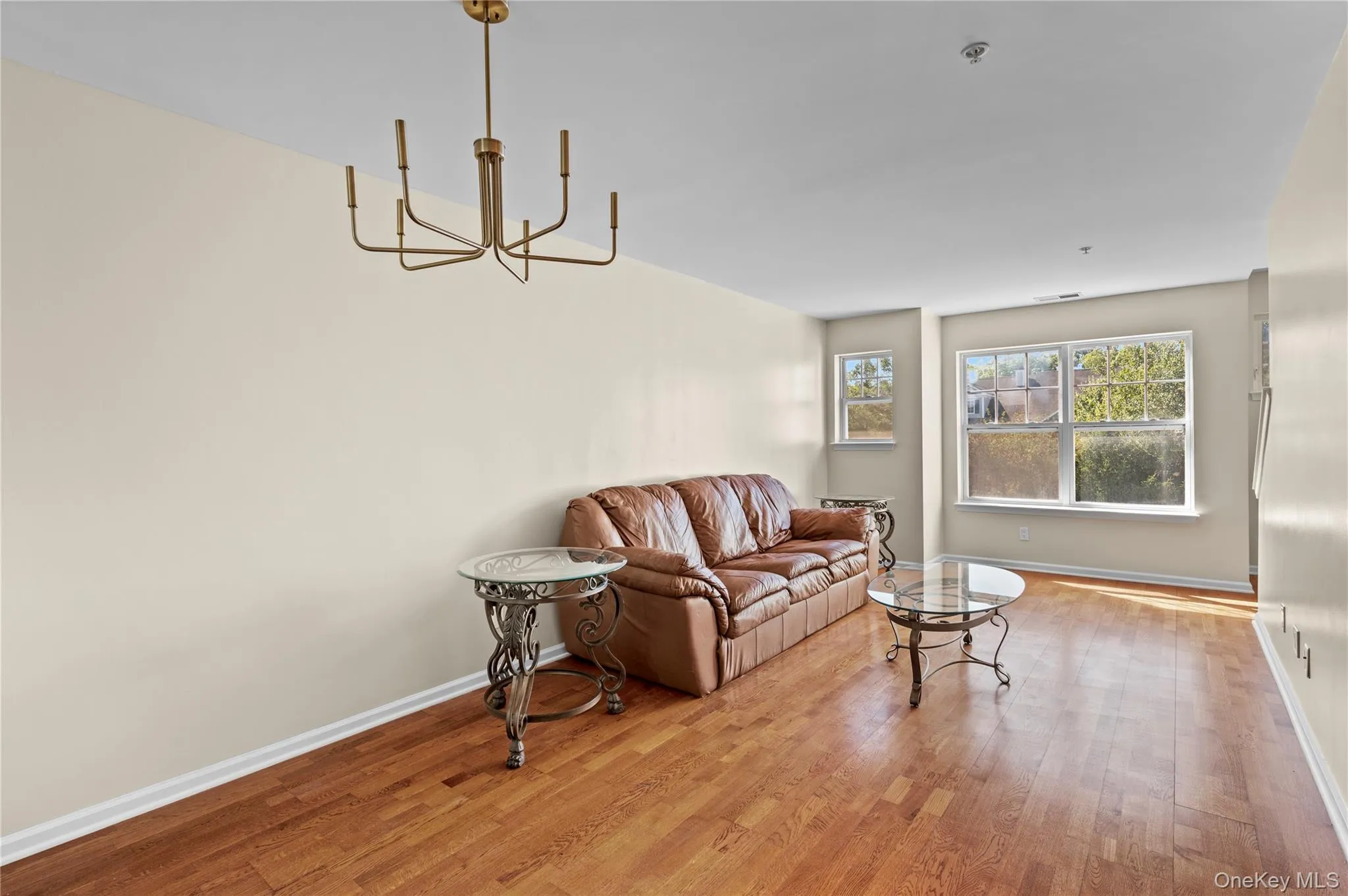 Living area with light wood finished floors and a chandelier Living area with light wood finished floors and a chandelier
